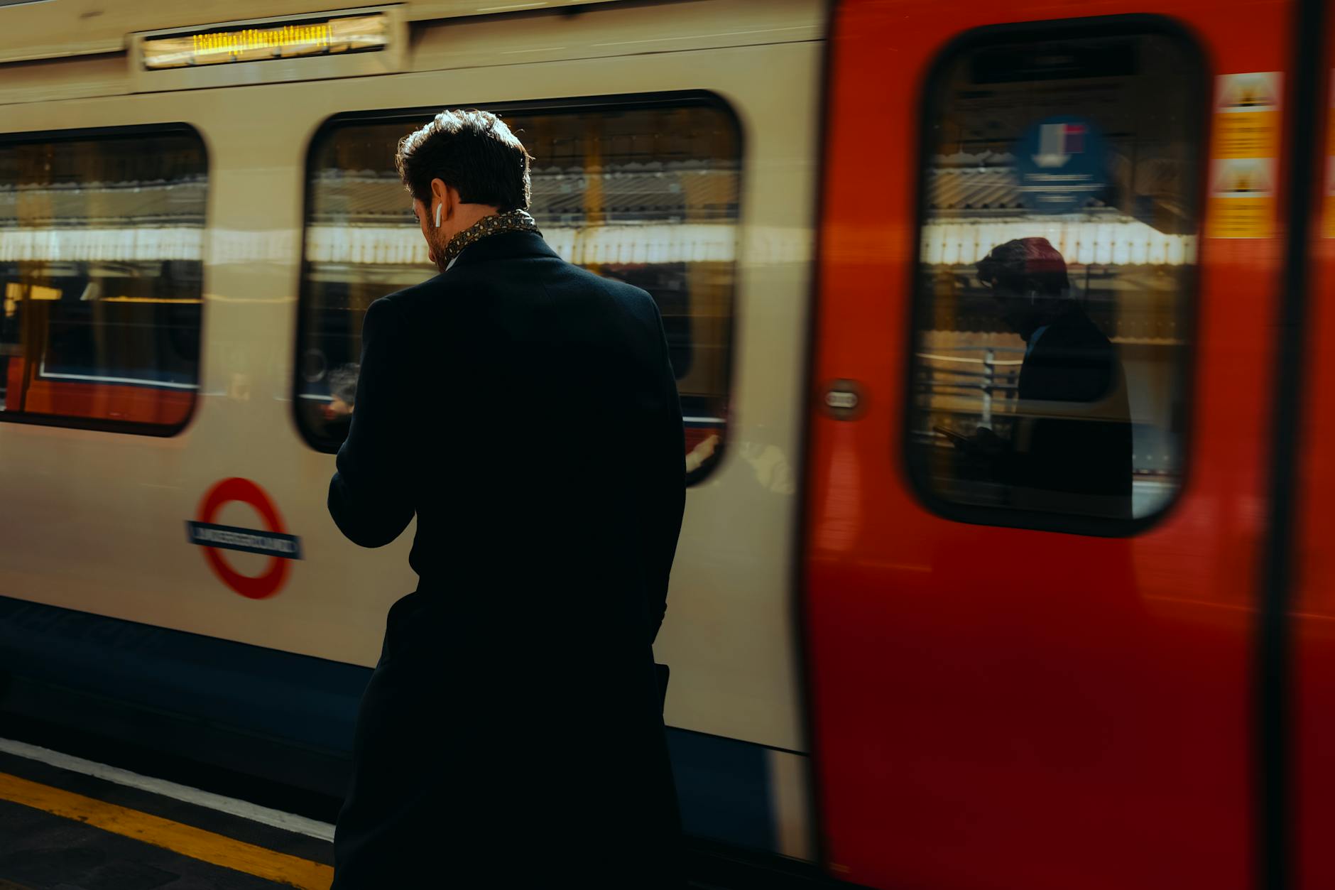 Traveler moving past a London Underground train platform