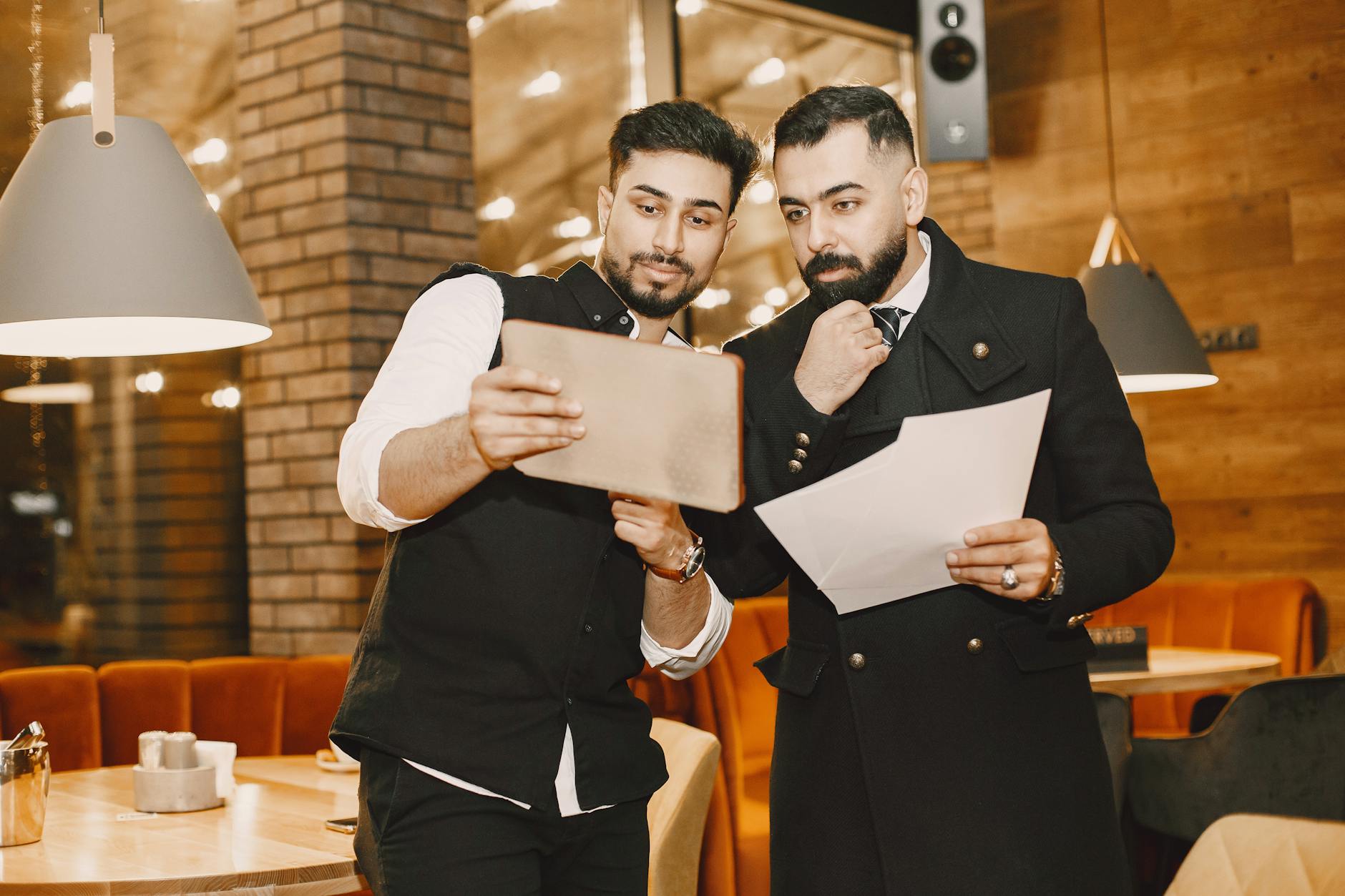 Business documents and tablet reviewed during a restaurant meeting