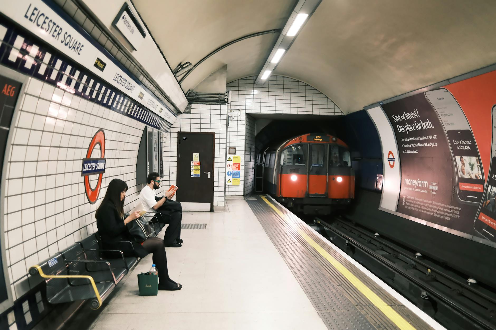 Passengers waiting as a train arrives at Leicester Square Underground station
