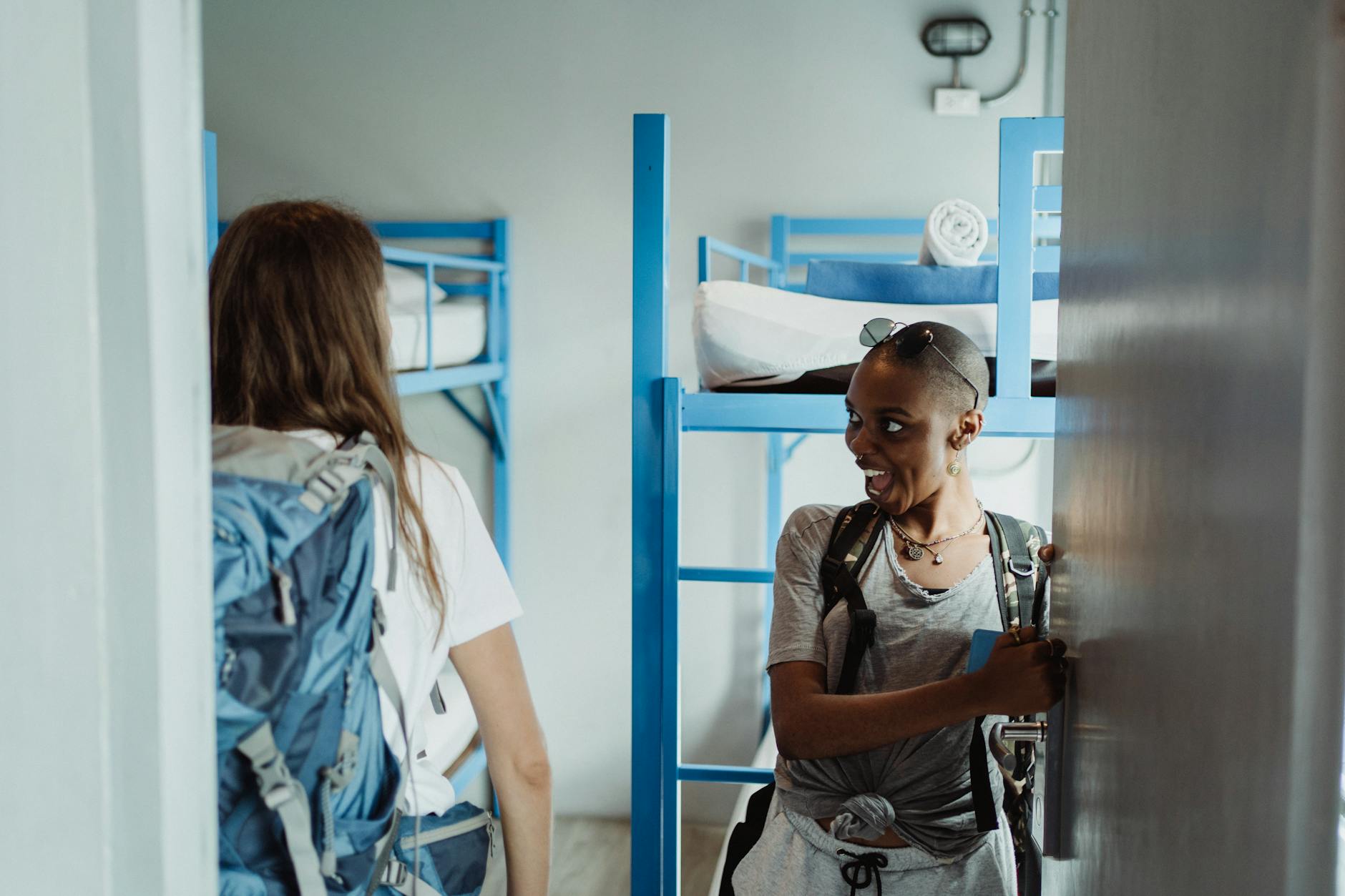 Backpacked travelers entering a shared dormitory room
