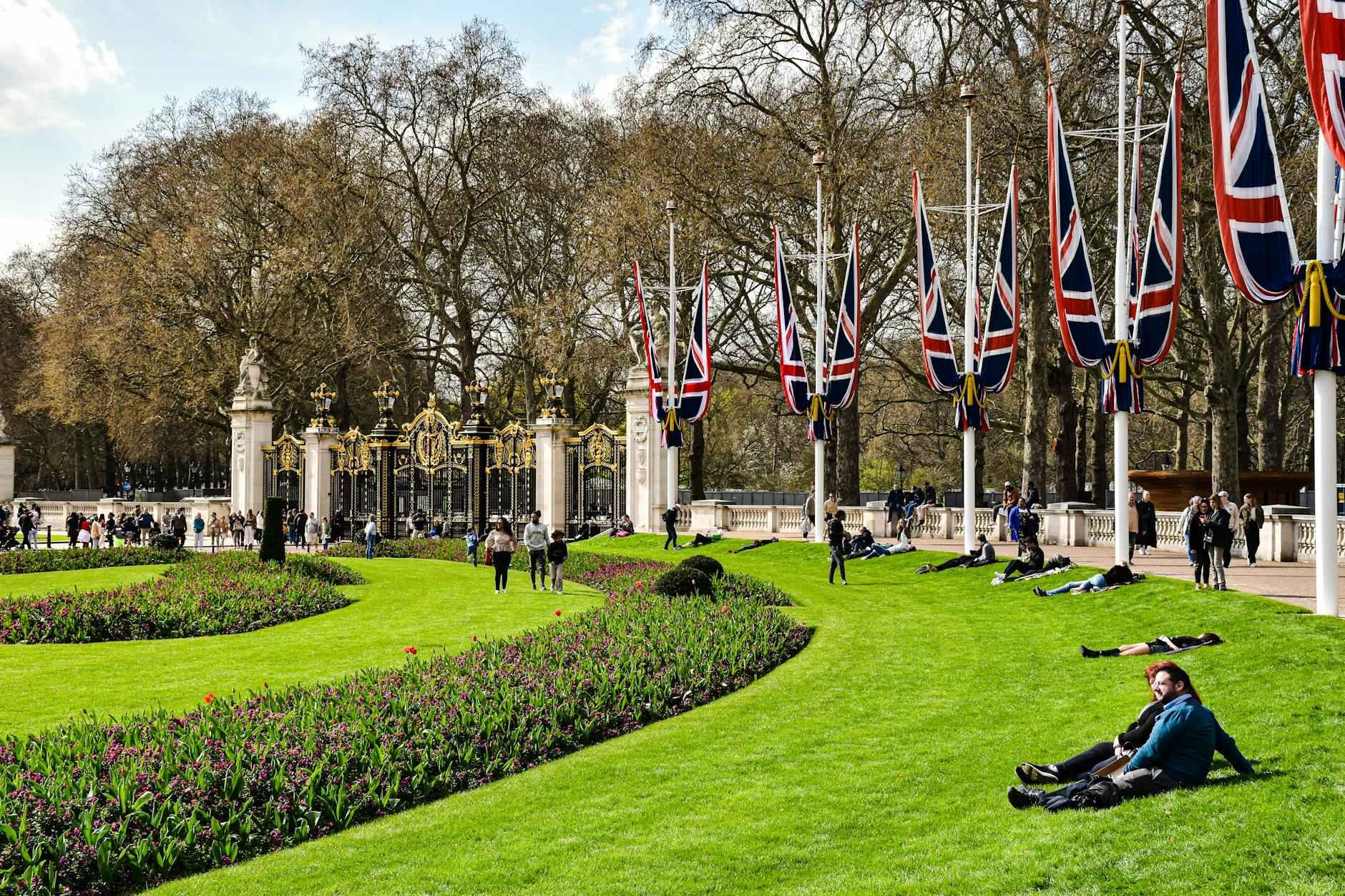 Tourists in gardens near Buckingham Palace on a sunny London day