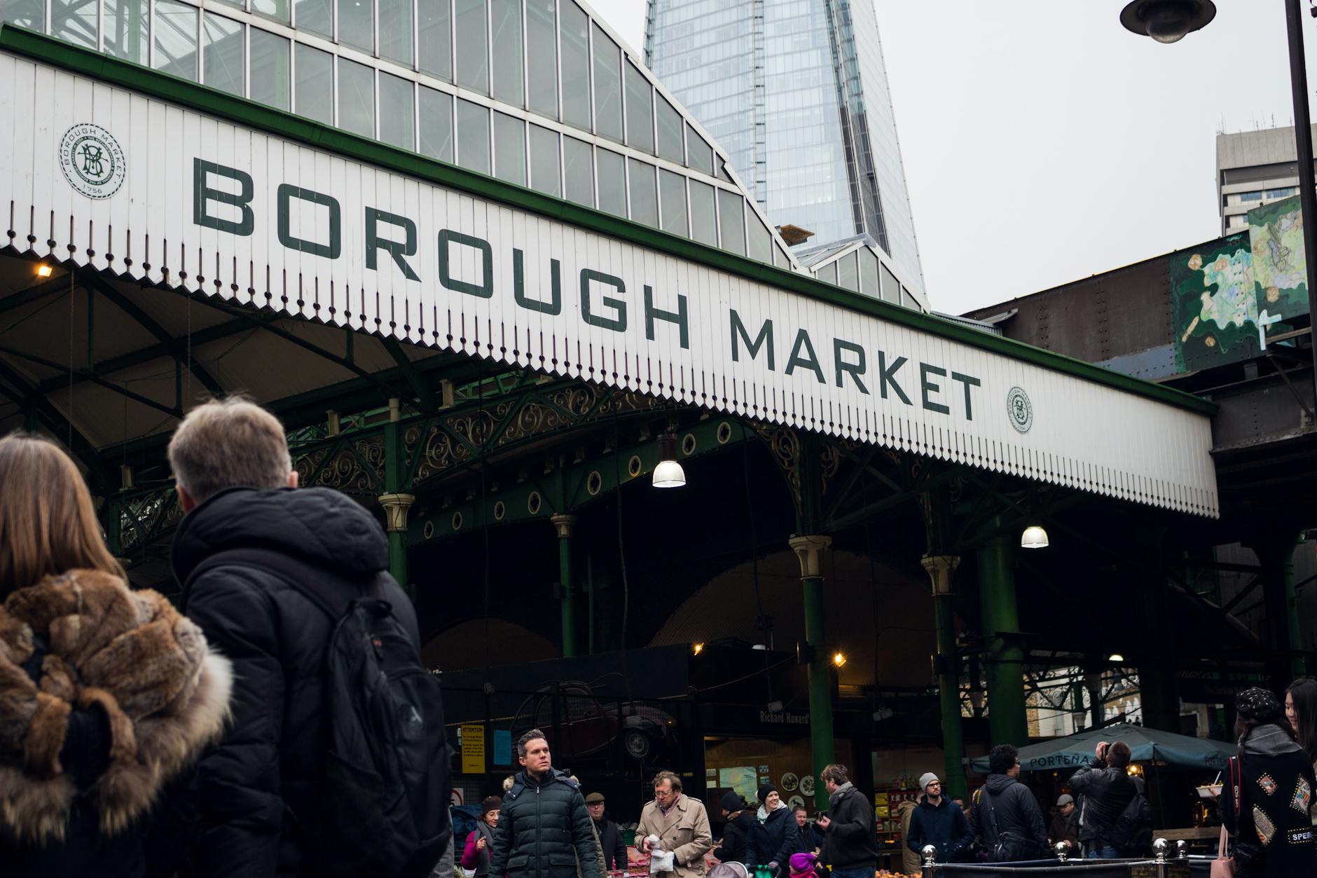 Busy Borough Market with visitors and London skyline context