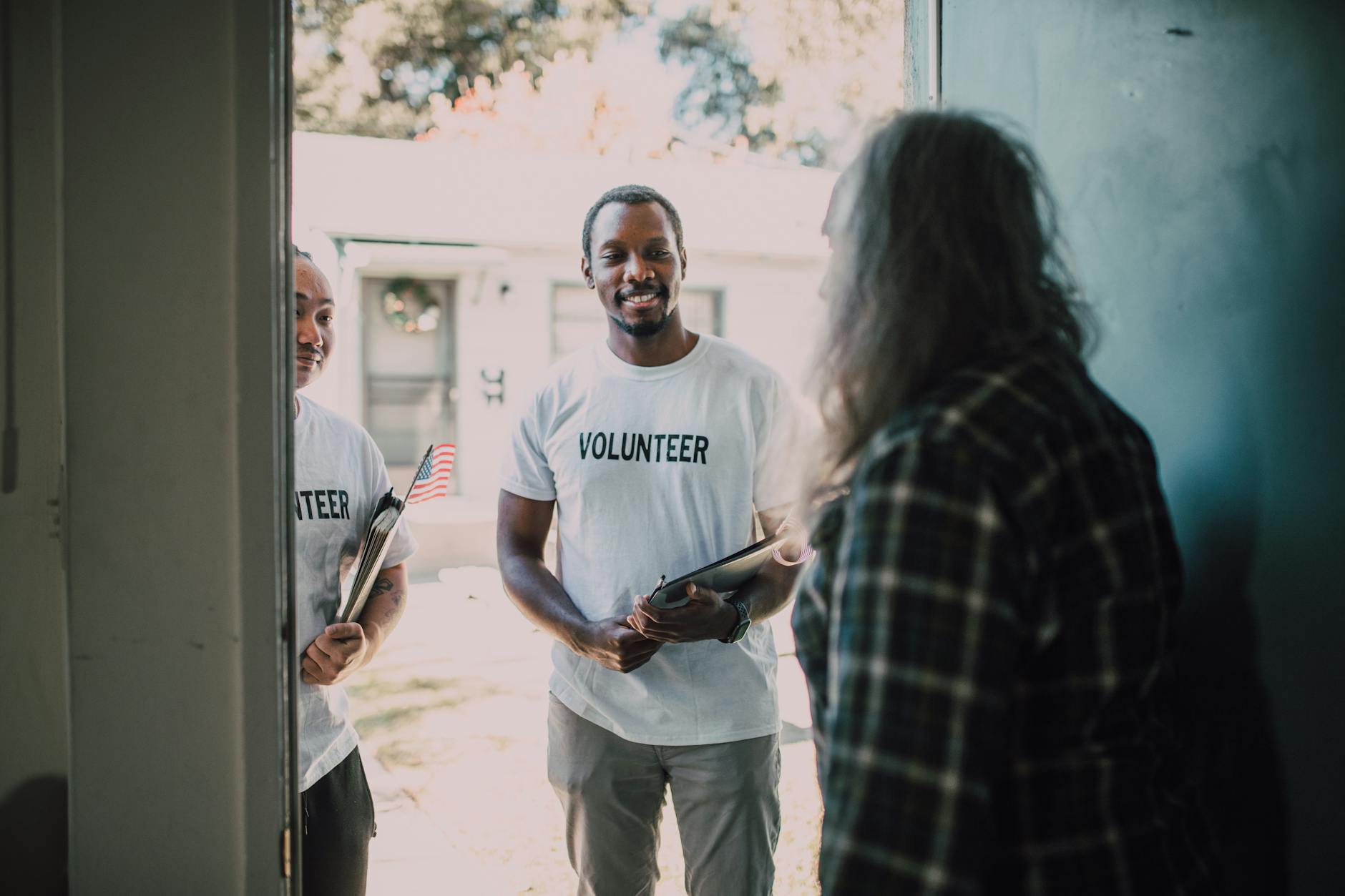 Volunteers with documents visiting a home for community support