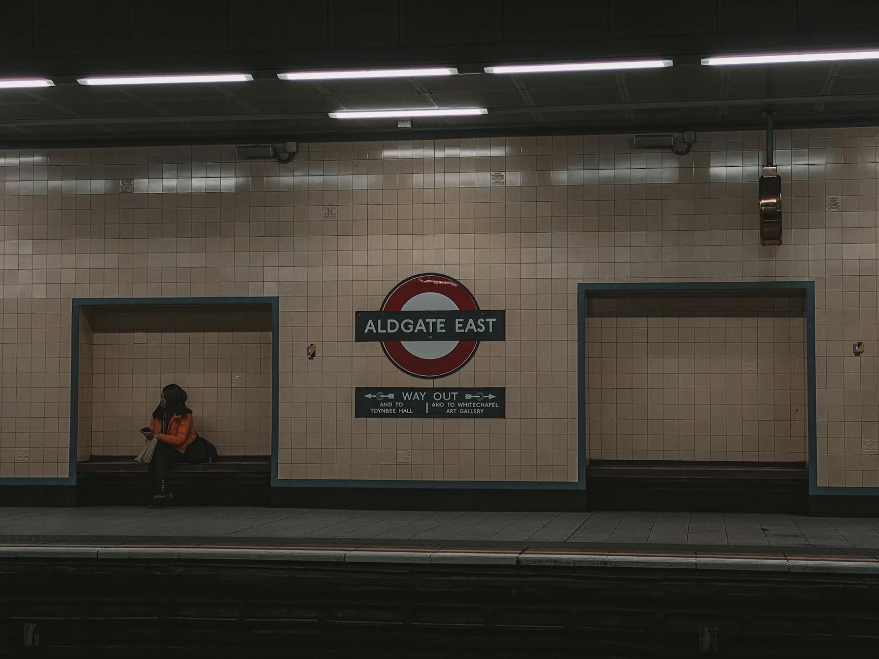 Woman waiting on an Aldgate East London Underground platform