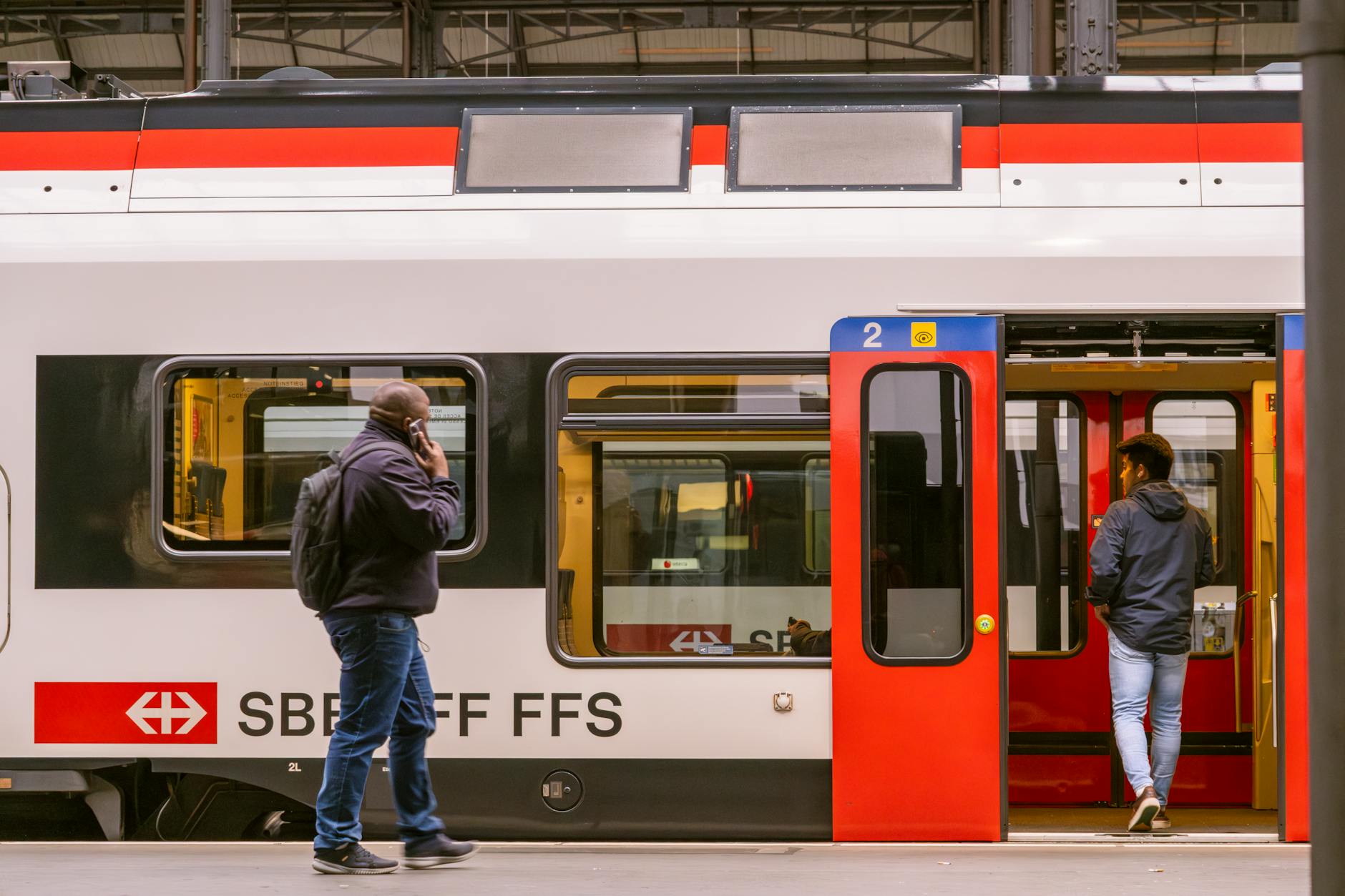 Travelers boarding an SBB train at Lucerne station for conference arrival planning.