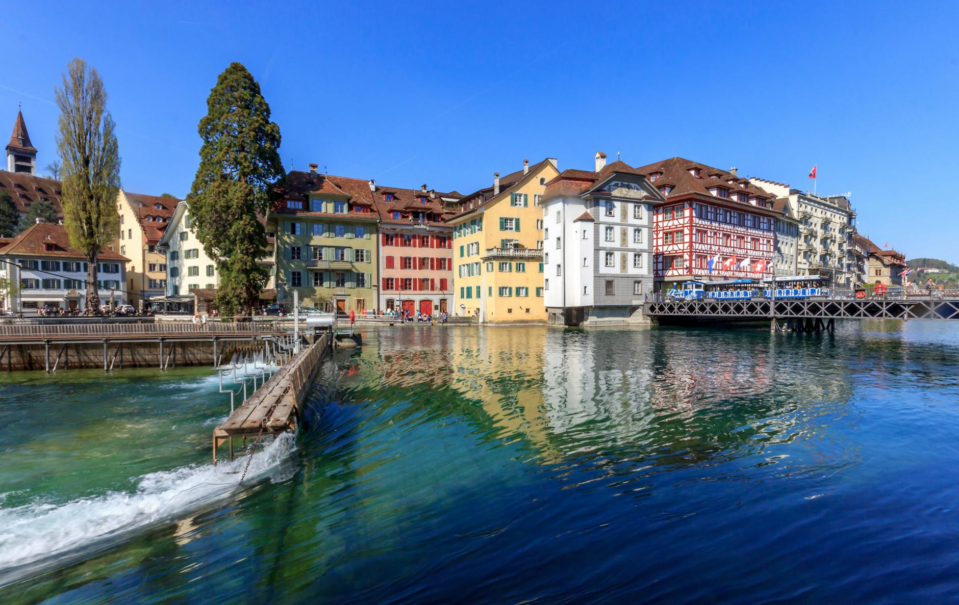 Colorful riverside buildings in Lucerne for budget meal and walking plans.