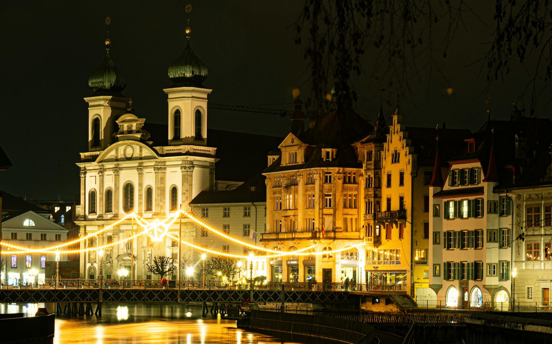 Illuminated Jesuit Church and Reuss River in Lucerne for consultant evening planning.