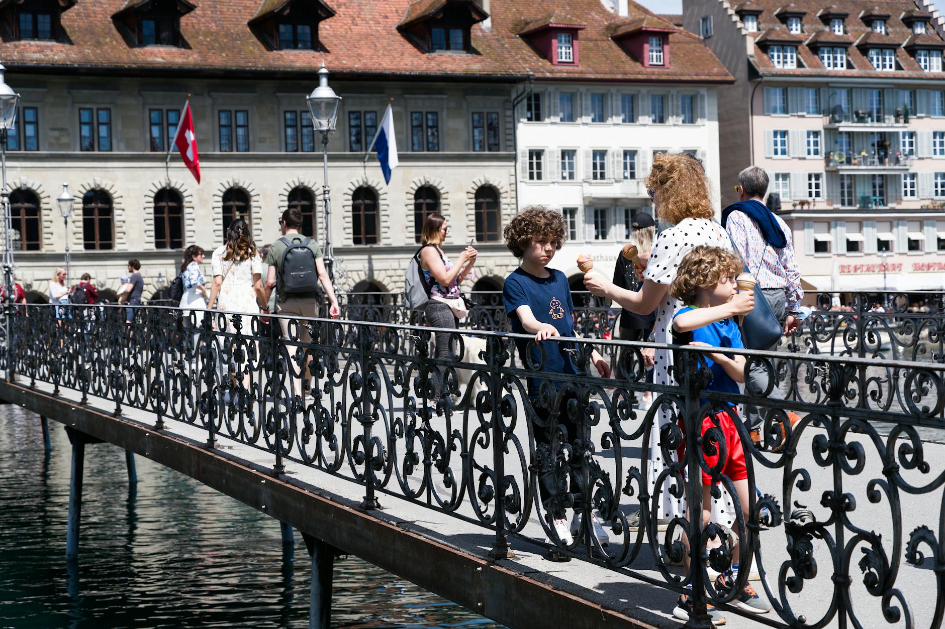 People and children on Chapel Bridge in Lucerne for family travel planning.