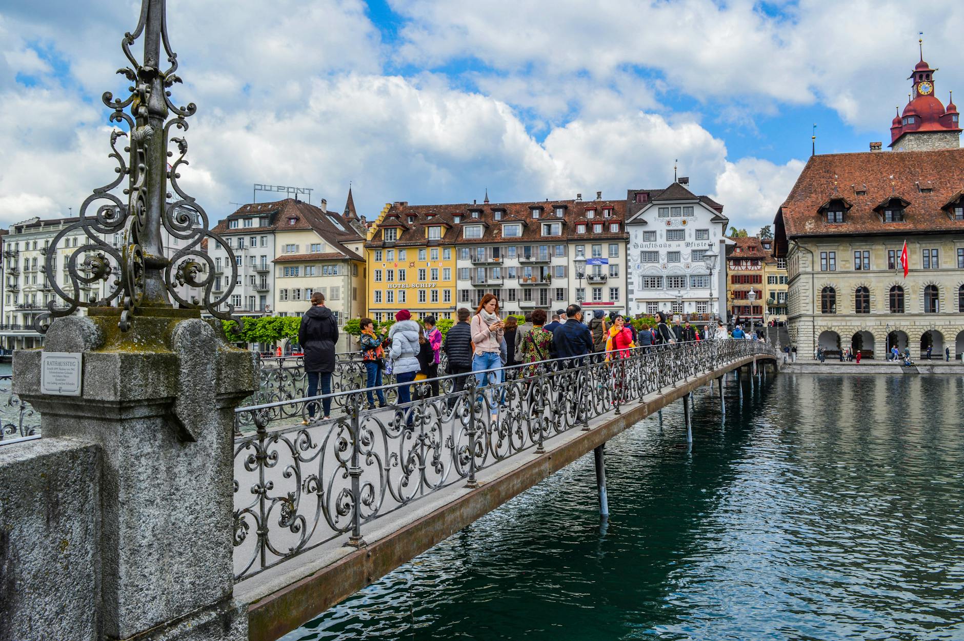 People walking Chapel Bridge in Lucerne for access and pacing planning.