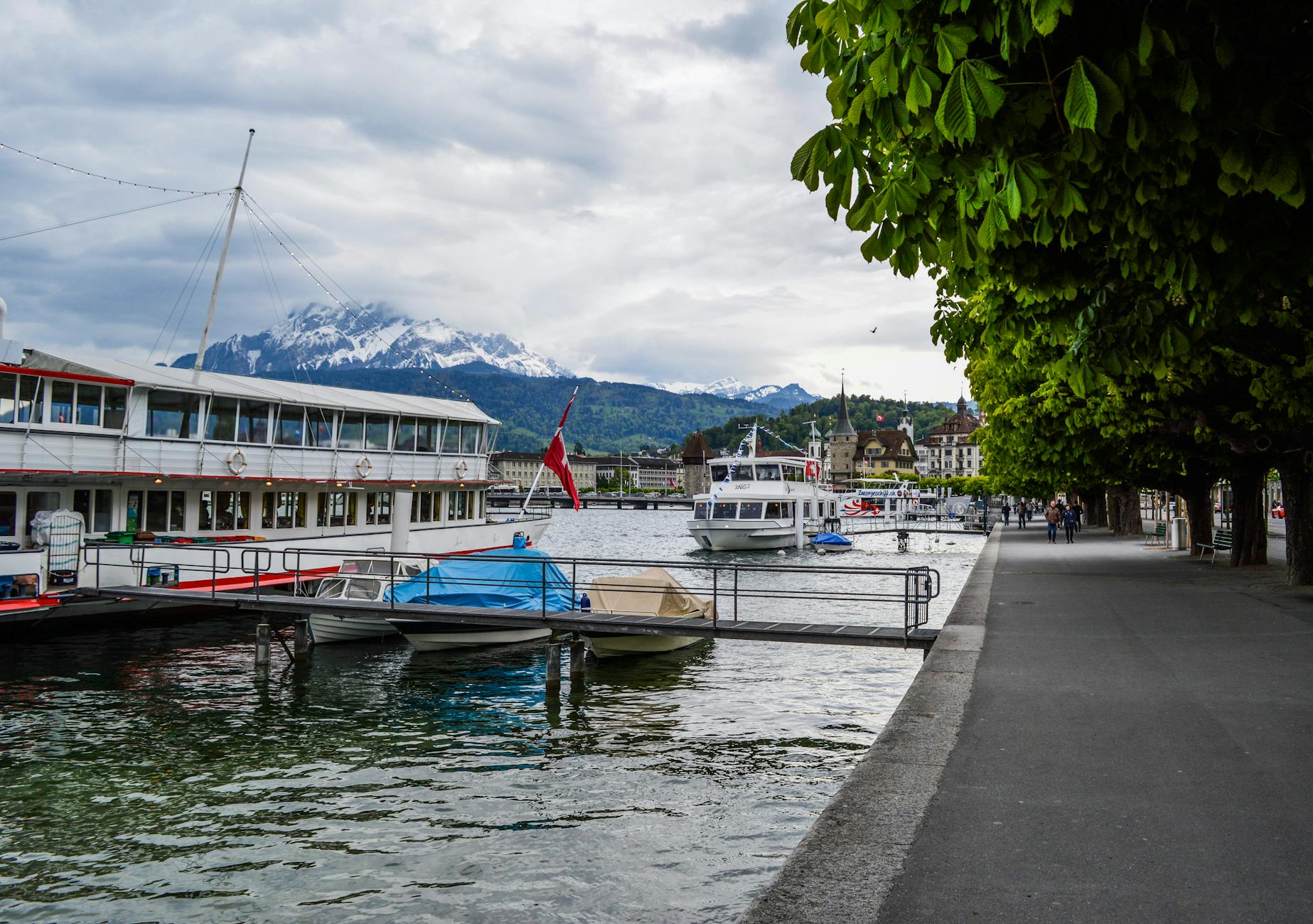Lucerne lakeside promenade and moored boat for older traveler planning.