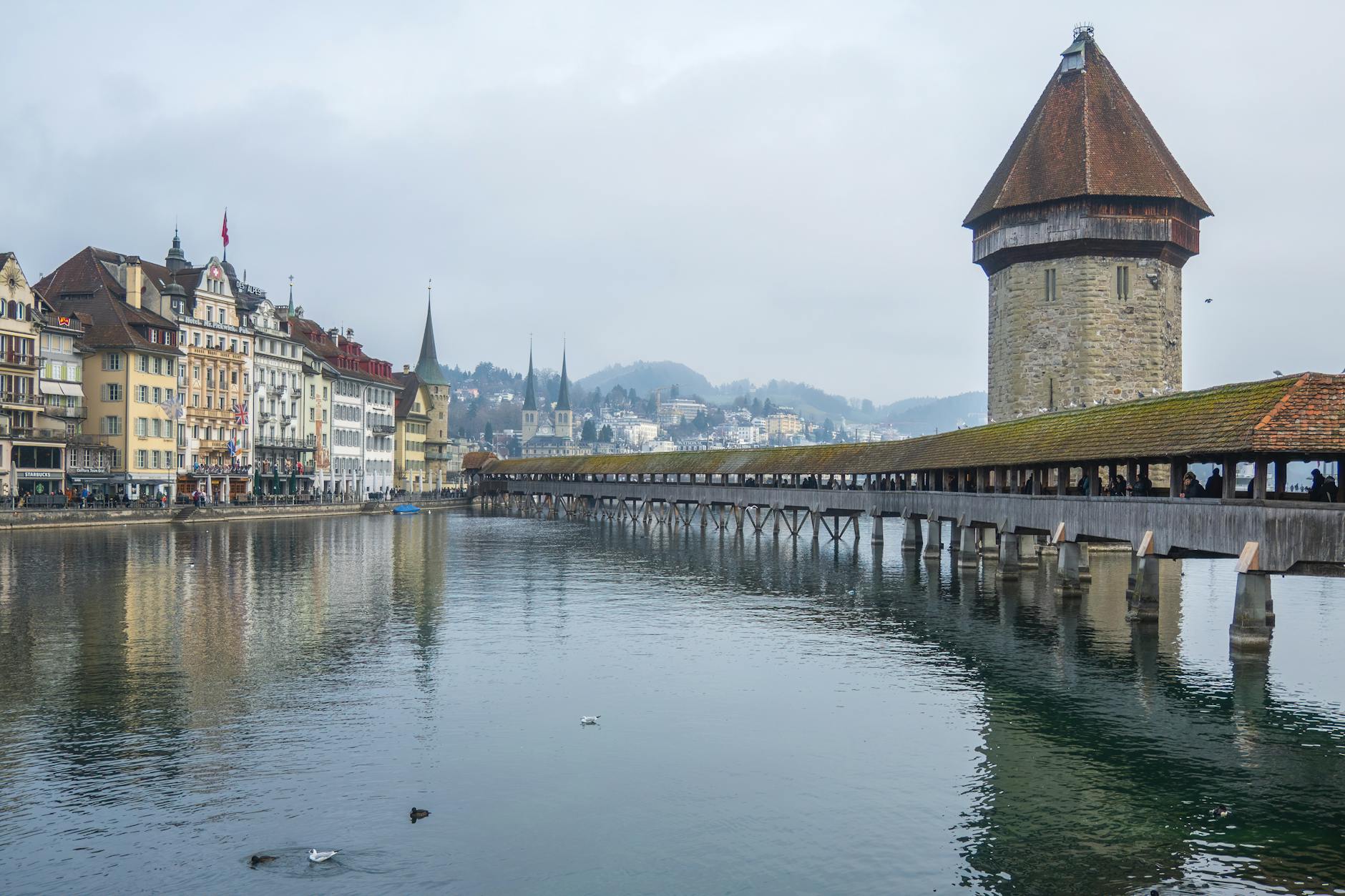 Chapel Bridge and Water Tower reflected in the Reuss River for tourist crowd planning.