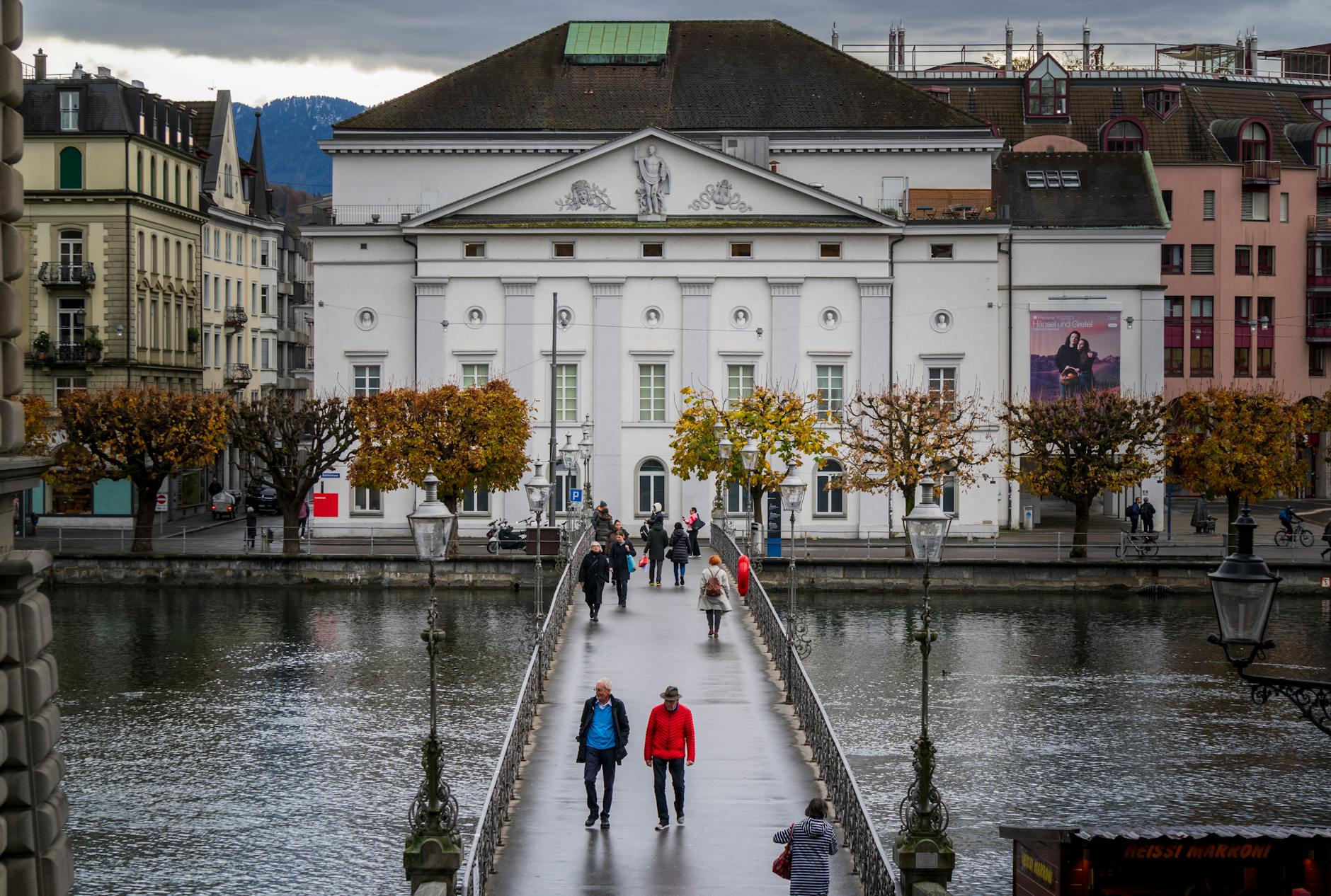 People walking near a Lucerne bridge for crowd and photo awareness.