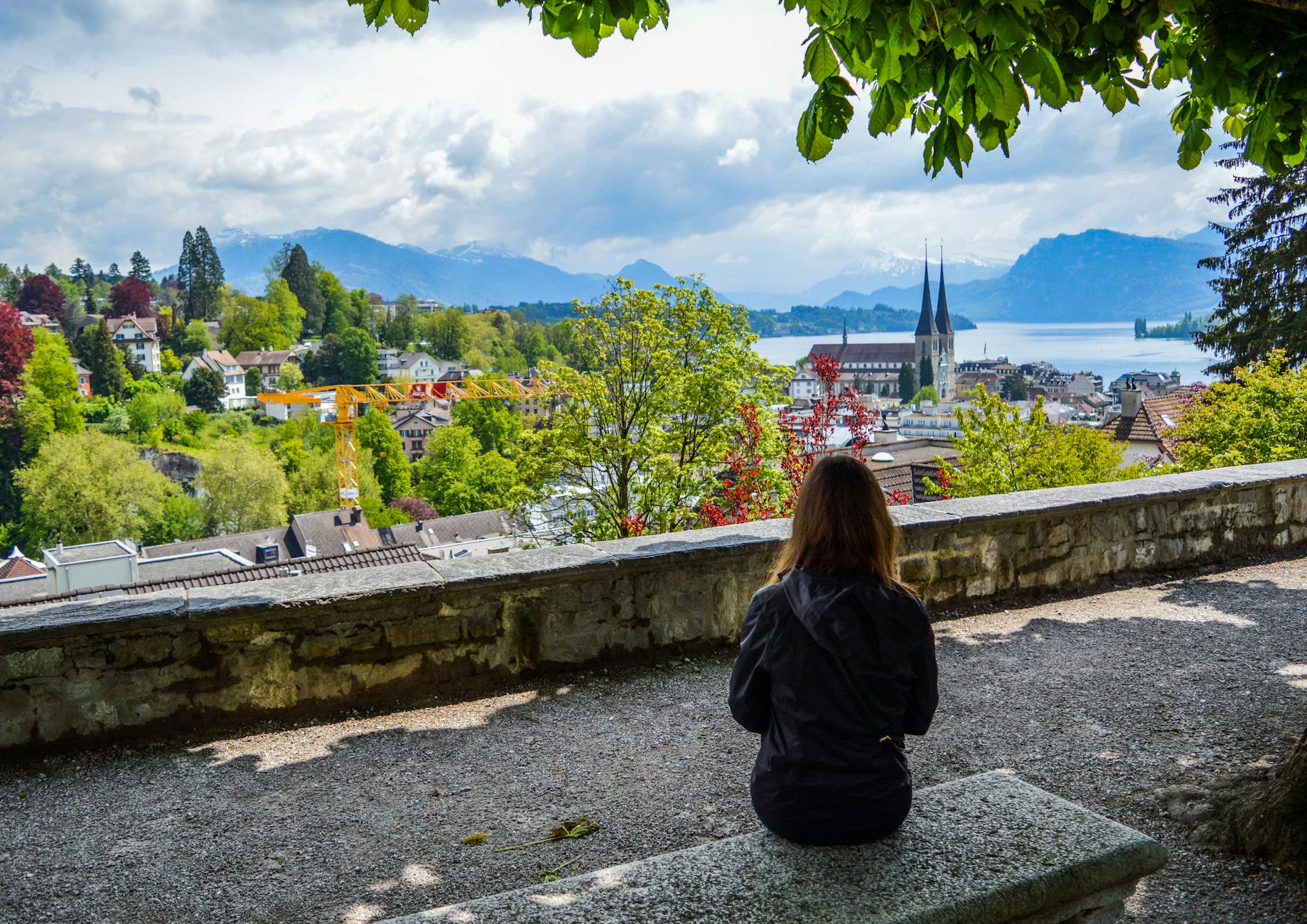 Woman overlooking Lake Lucerne and nearby mountains for travel planning.