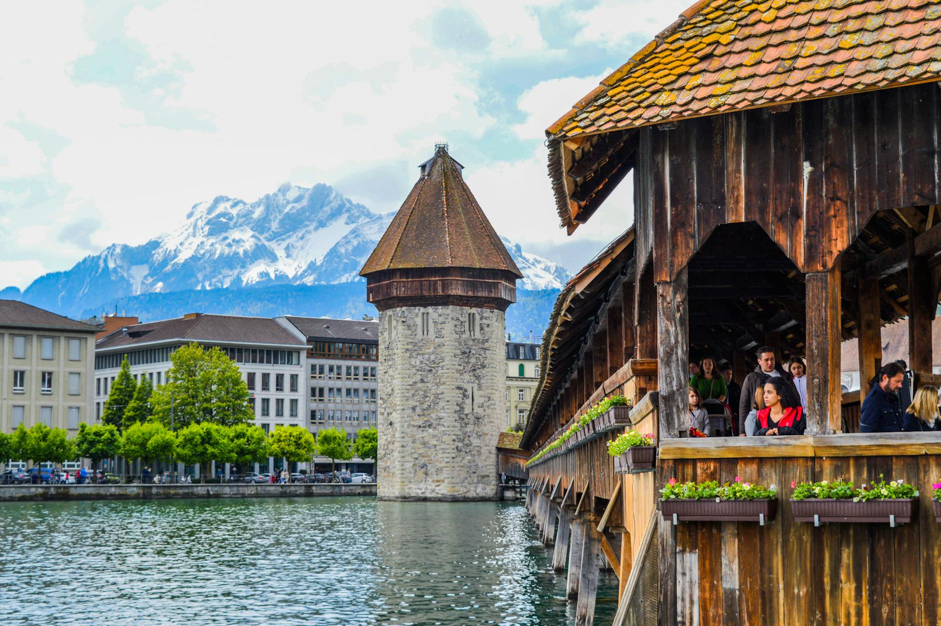 Travelers walking Chapel Bridge in Lucerne for arrival and route planning.