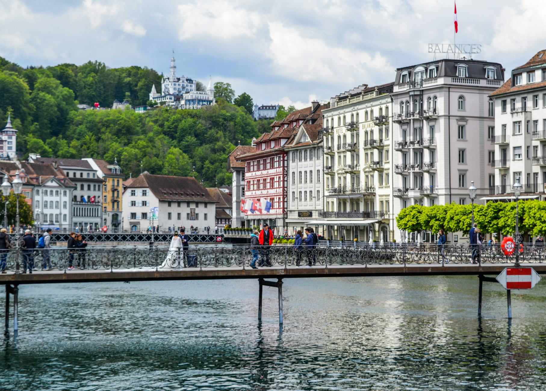 Pedestrian bridge and colorful Lucerne buildings for dining route planning.