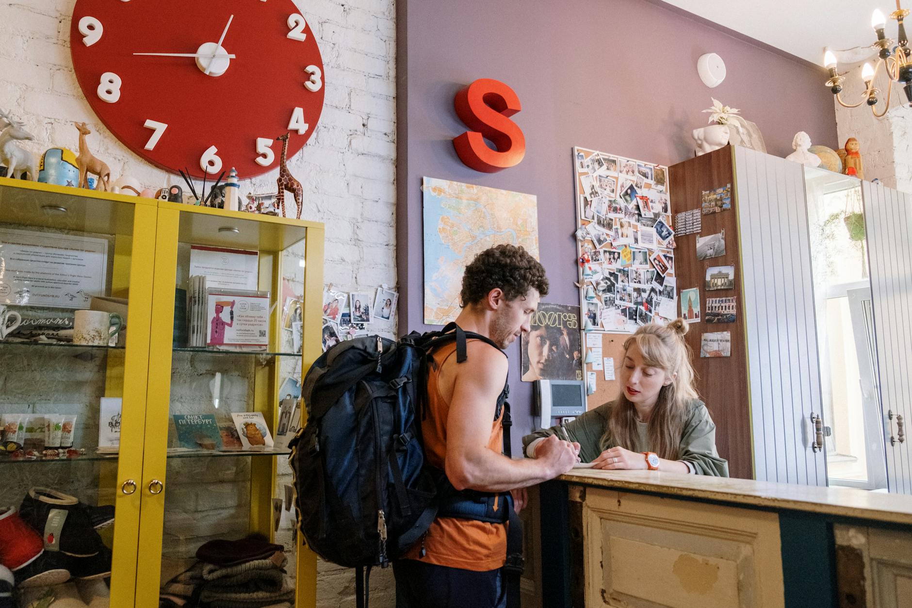 Backpacker receiving help at a hostel front desk