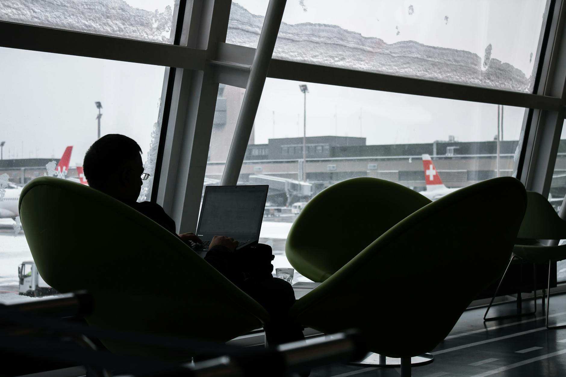 Business traveler working on a laptop in an airport lounge