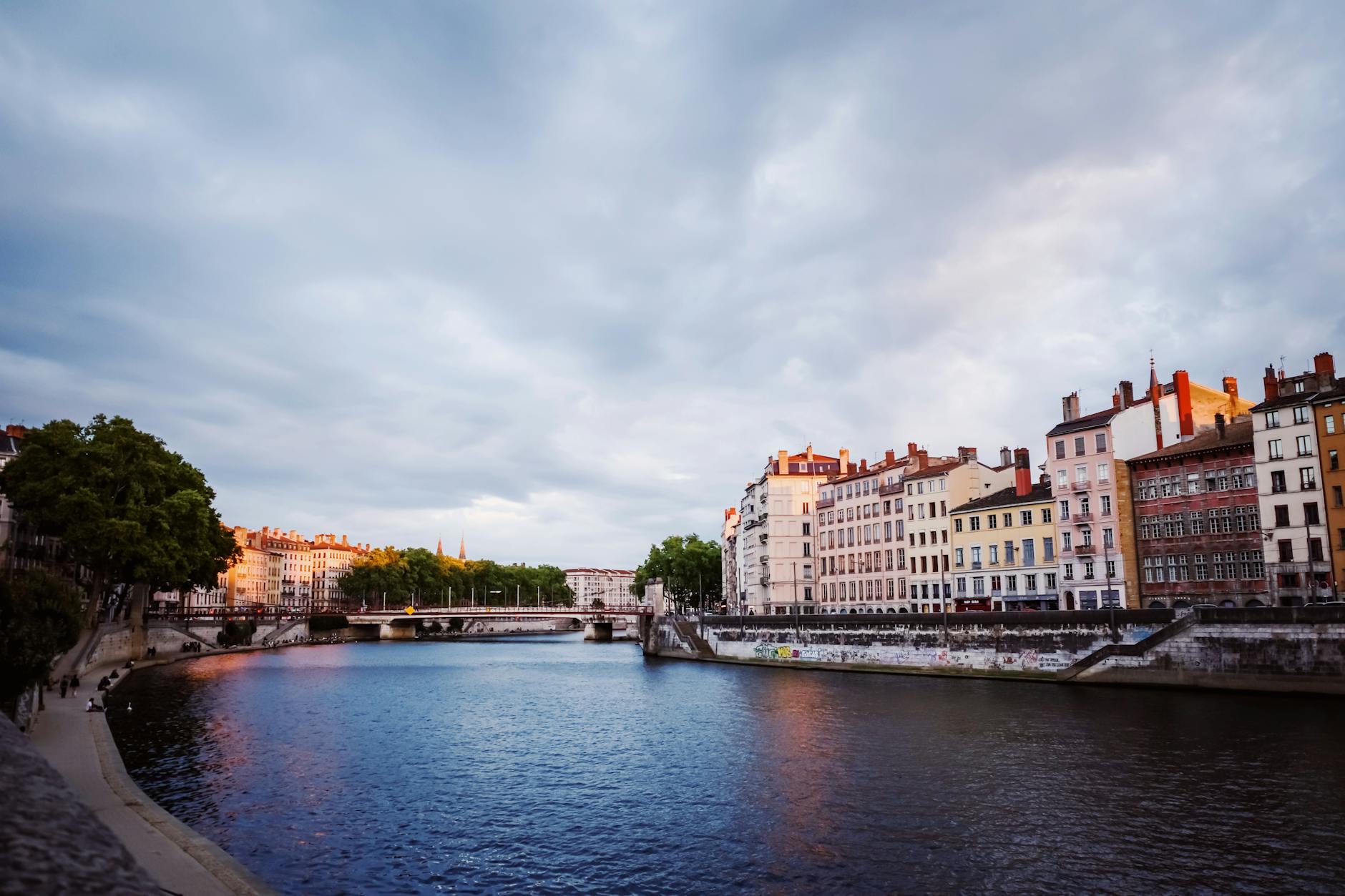 Colorful buildings reflected on a Lyon river in evening light