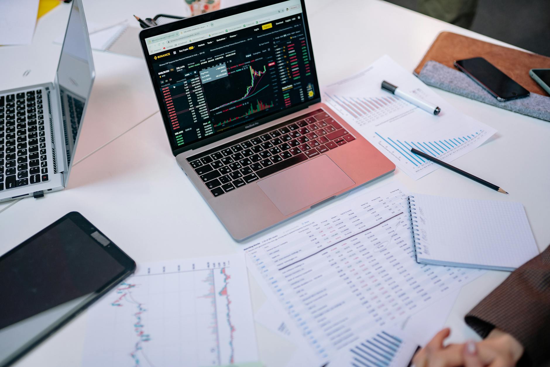 Laptop and financial charts on a desk