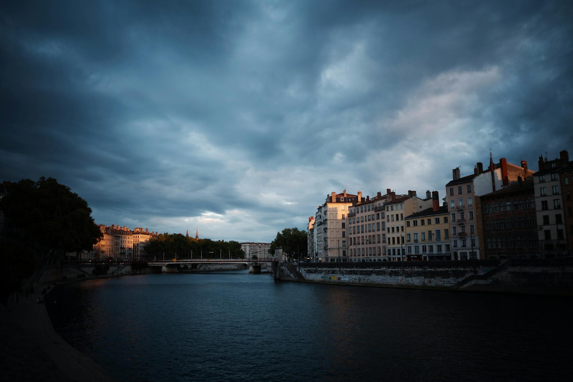 Moody evening view of Lyon riverfront buildings