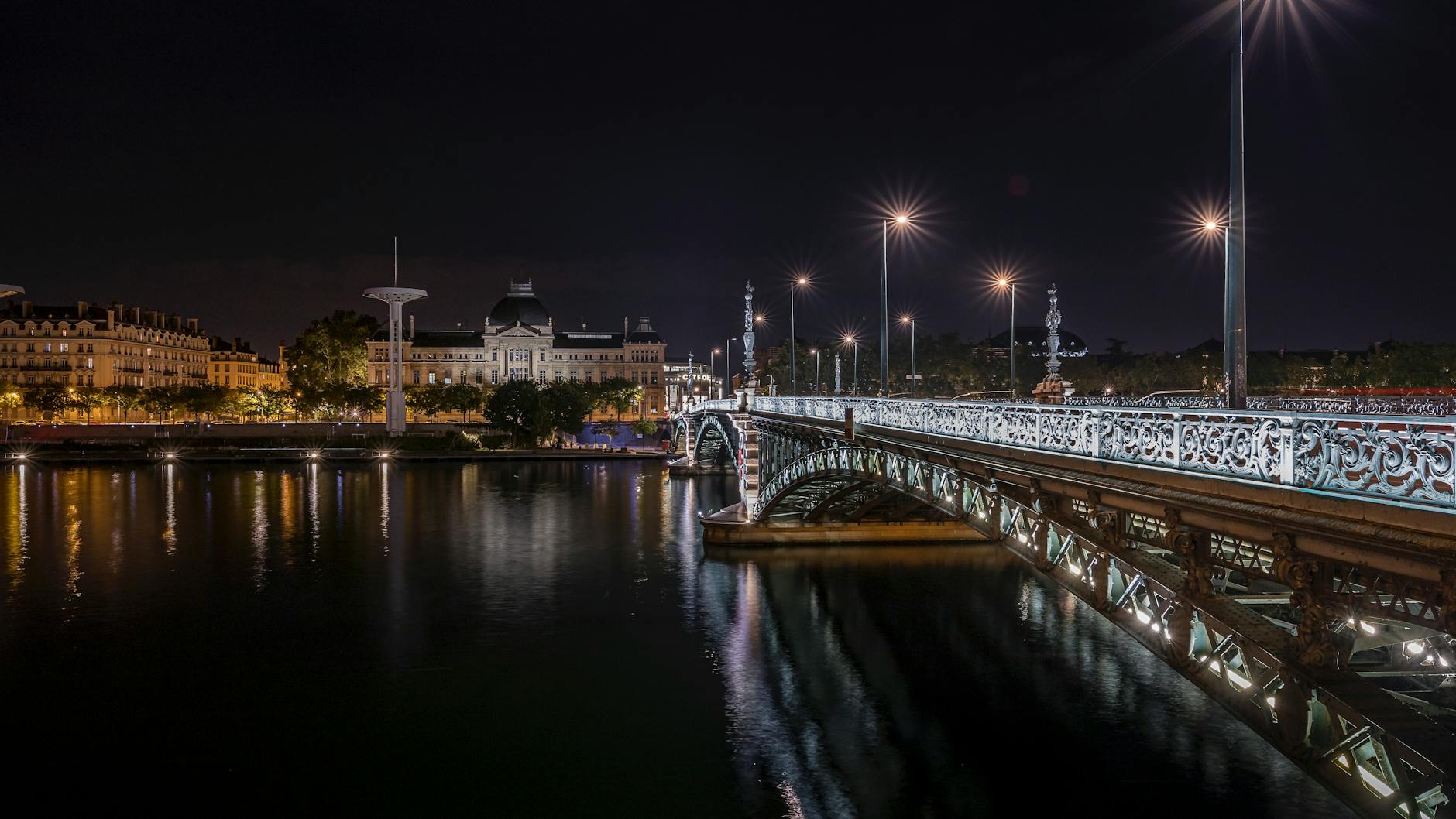 University Bridge illuminated at night over the river in Lyon