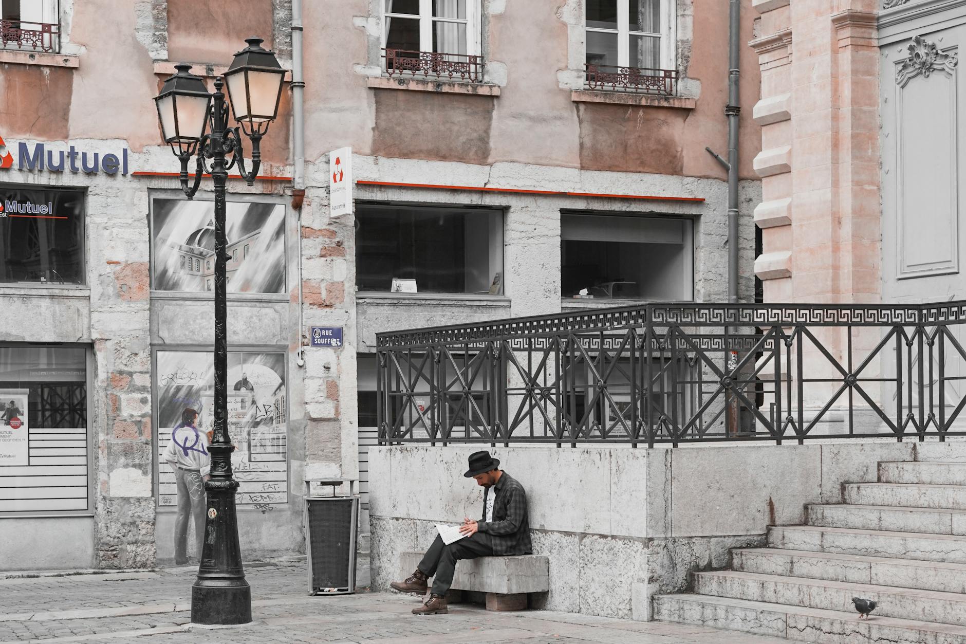 Man reading in a historic Lyon street corner