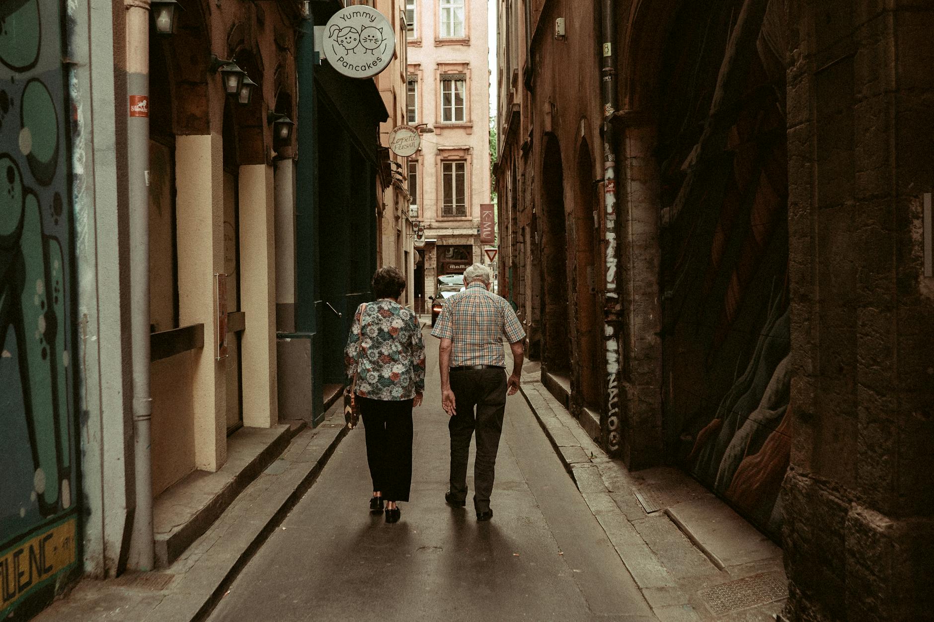 Older couple walking through a historic Lyon alley