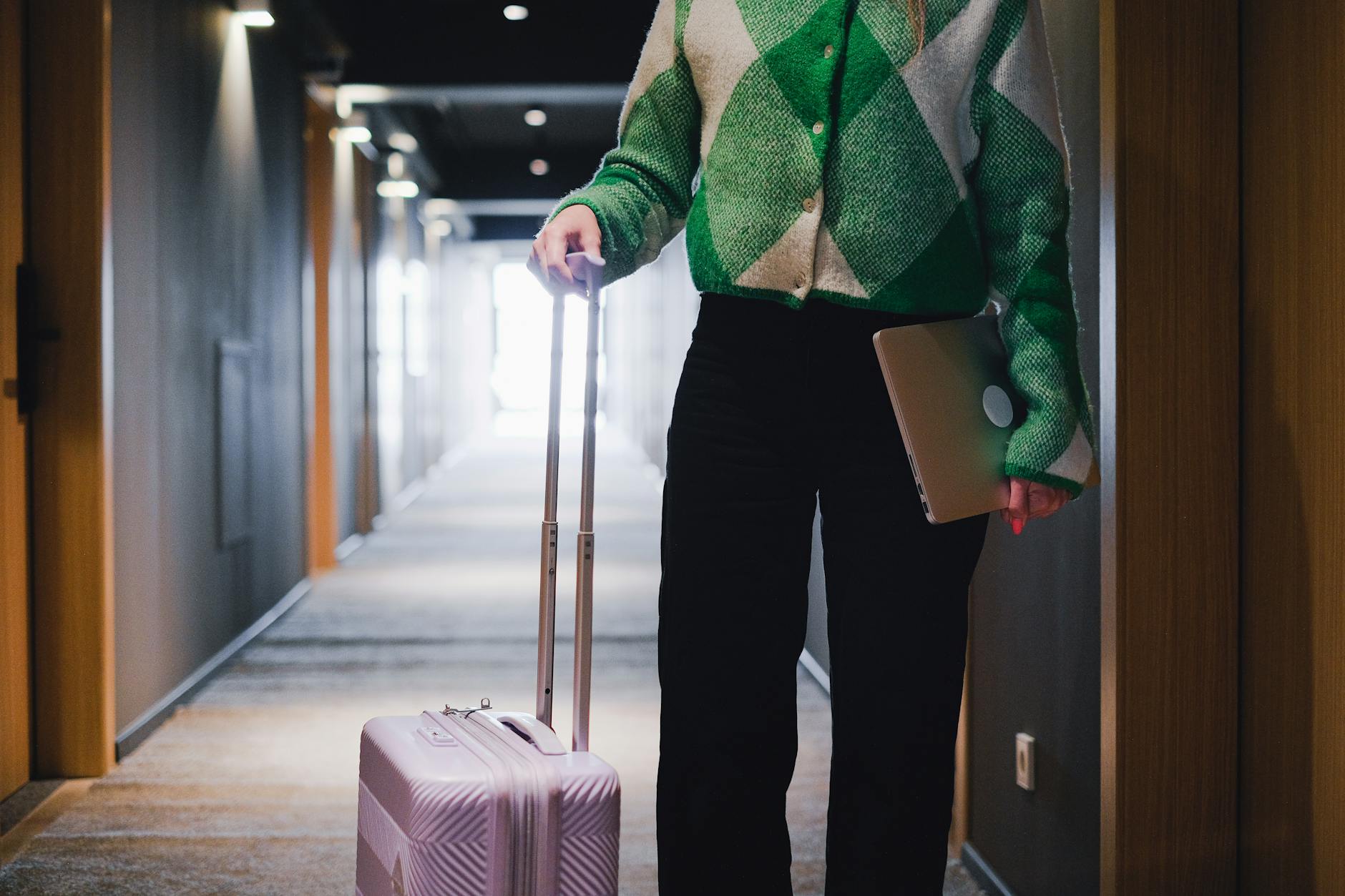 Business traveler with luggage and laptop in a hotel corridor