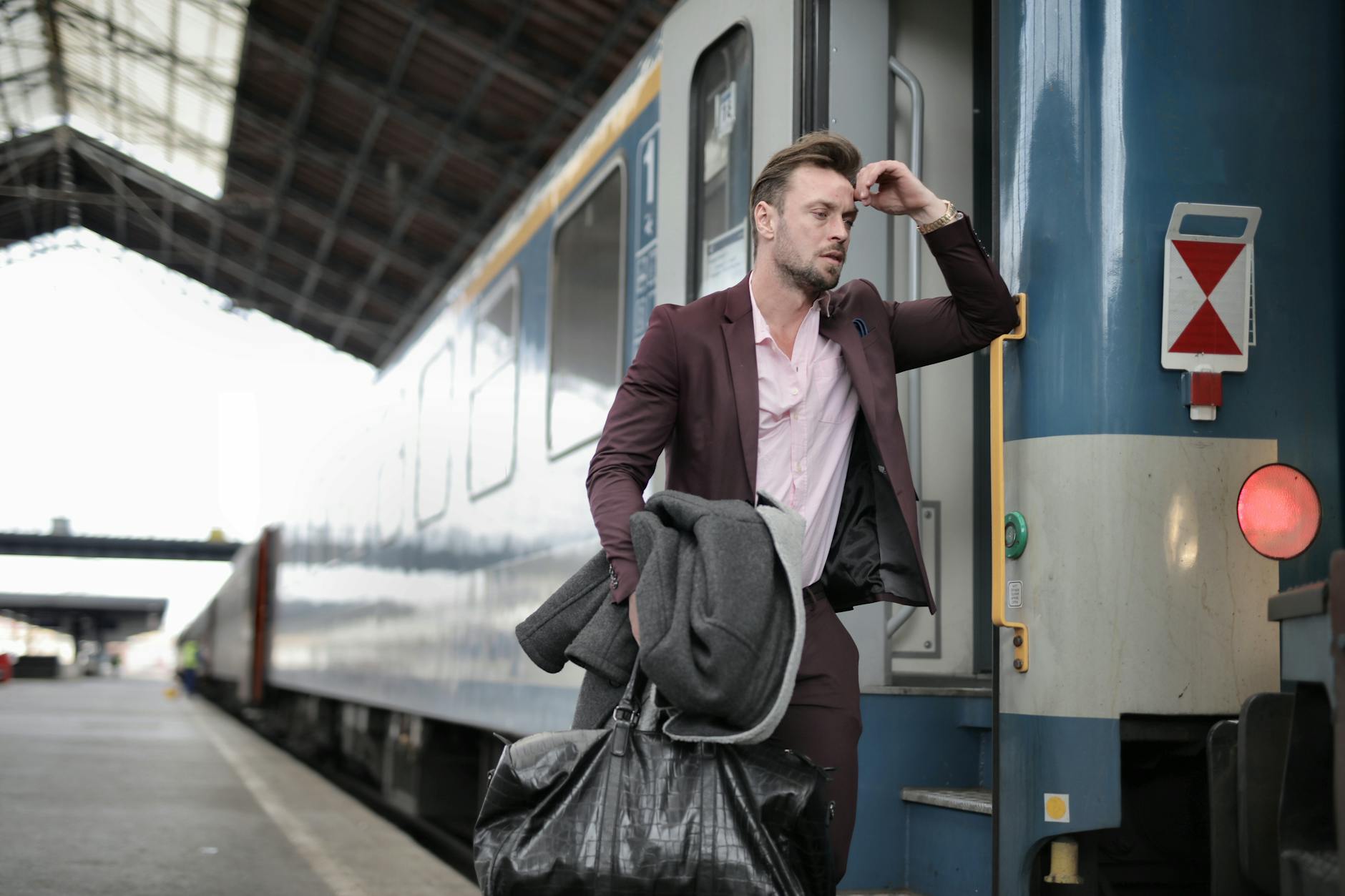 Business traveler carrying luggage while boarding a train
