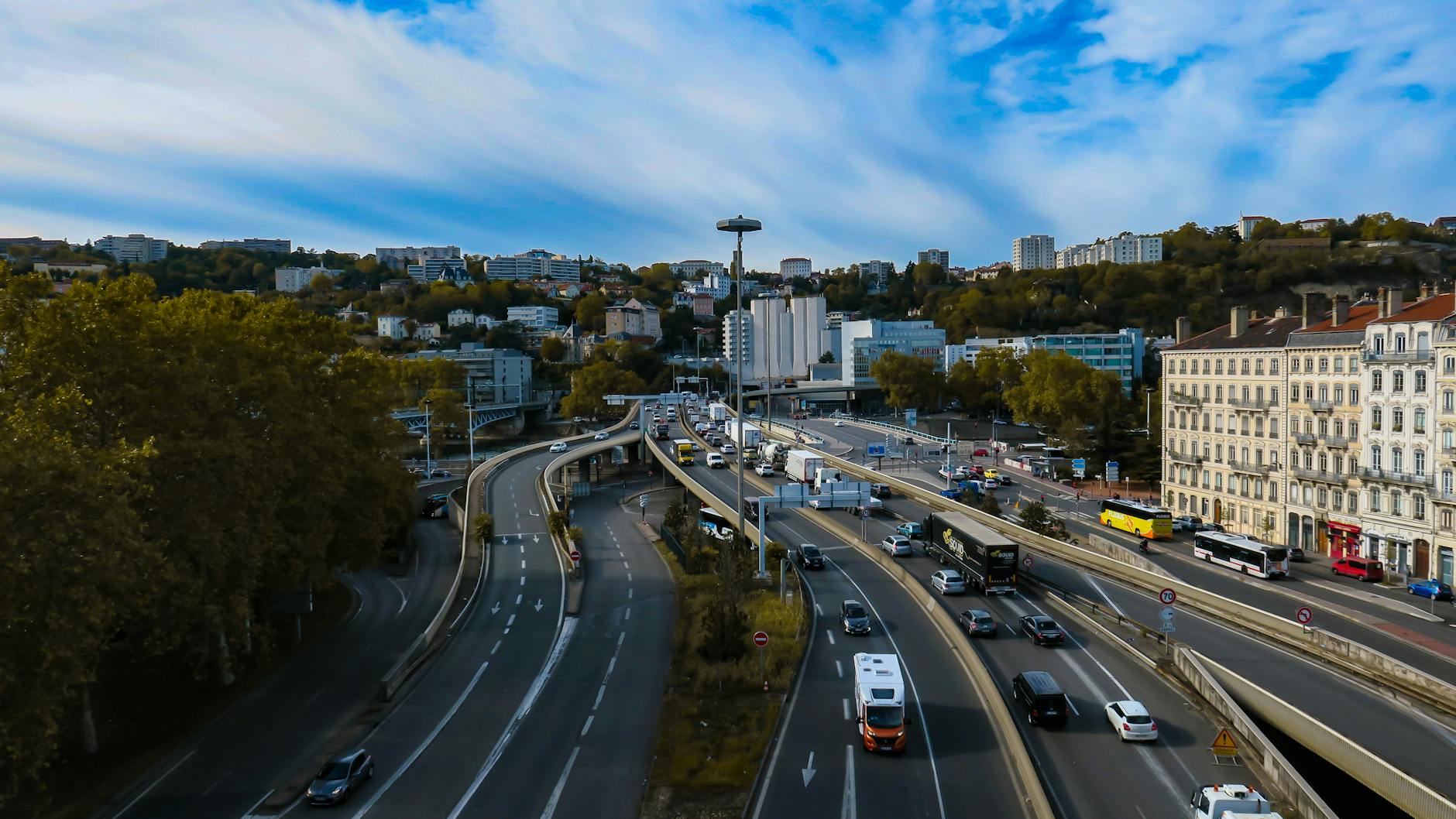 Vehicles moving through Lyon under a clear sky
