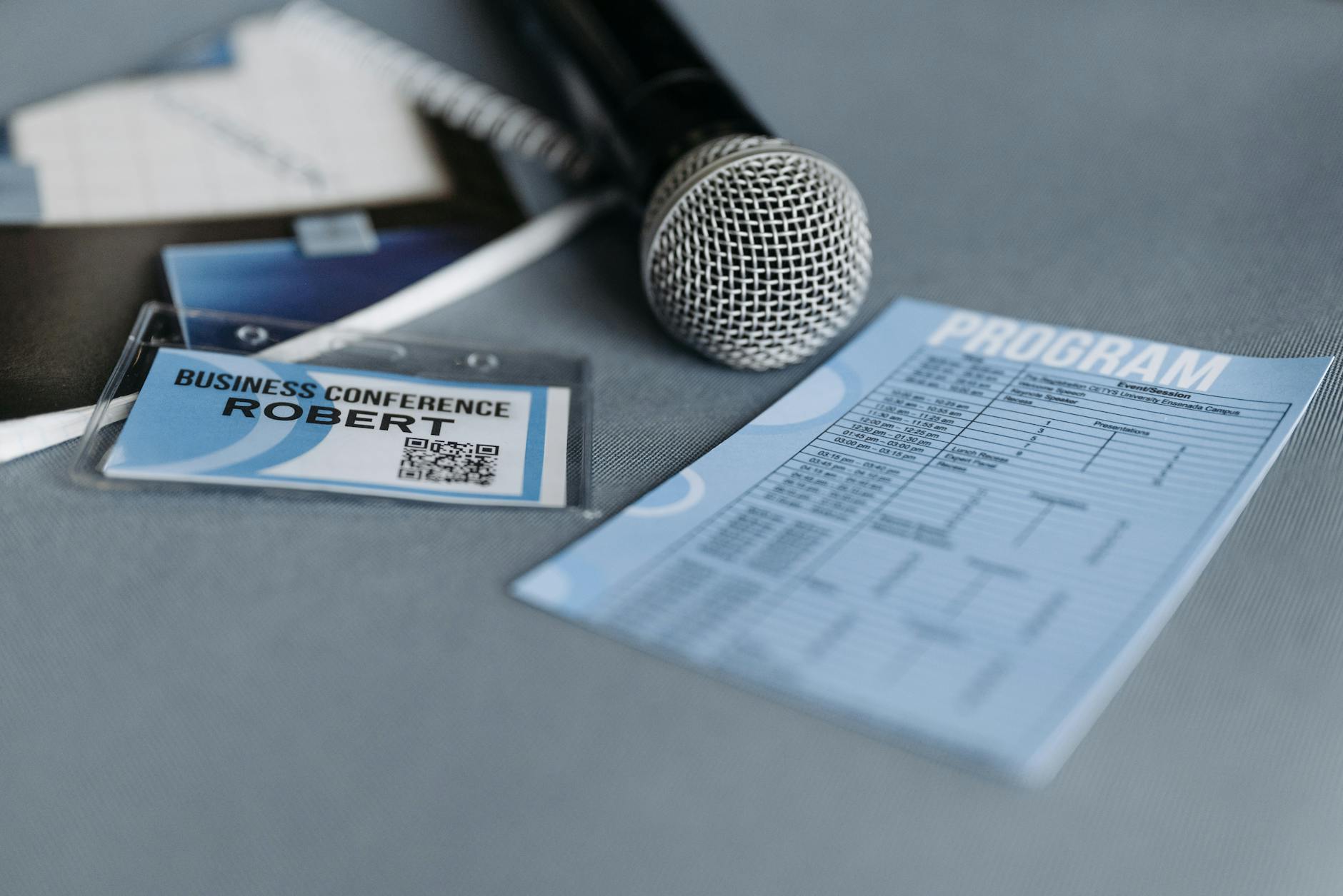 Conference badge, microphone, and program on a table