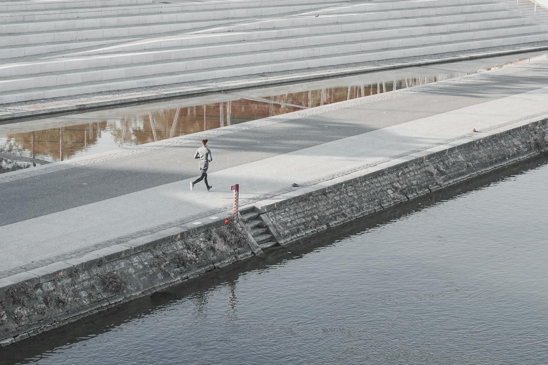 Person jogging along a riverbank in Lyon
