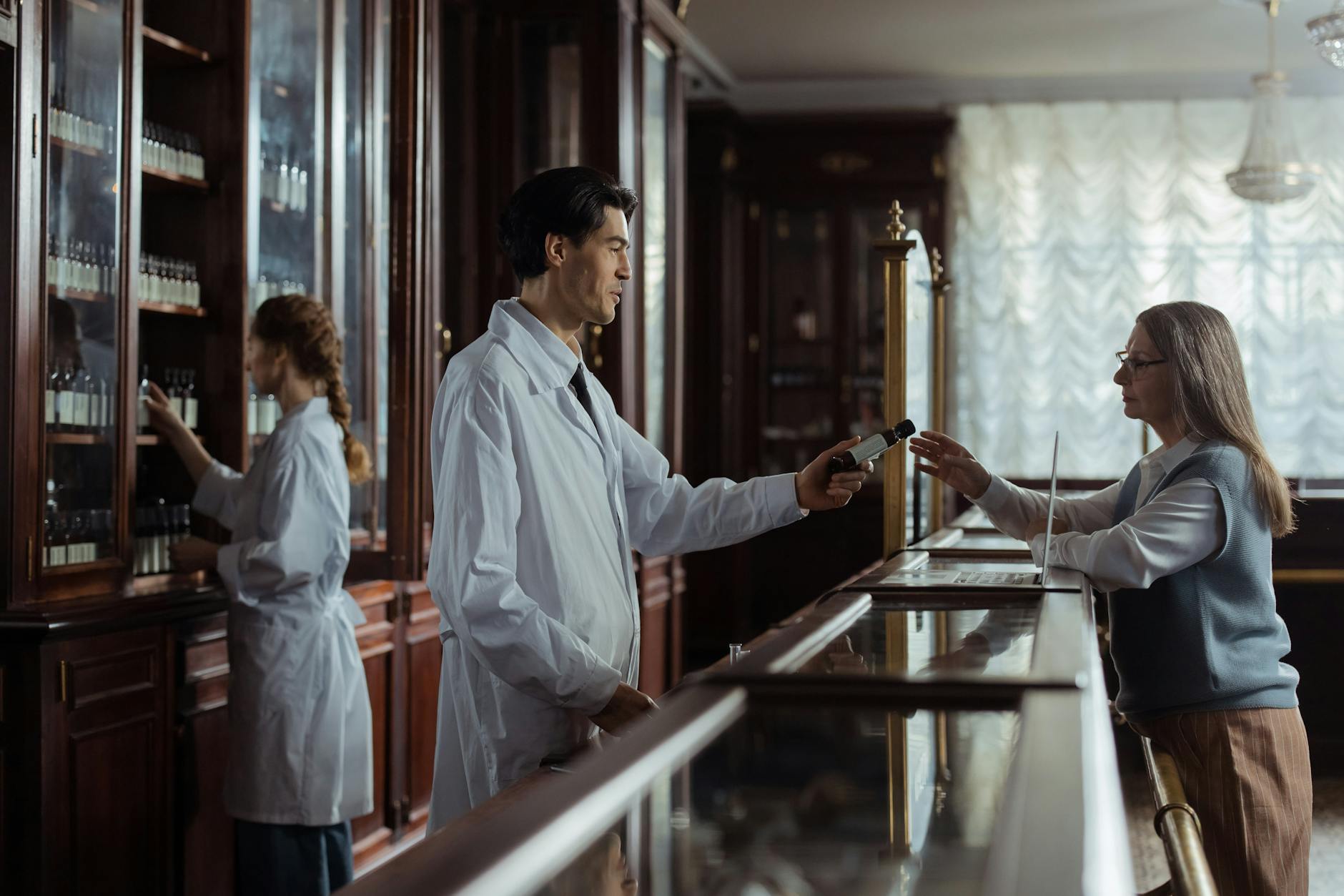 Pharmacist handing medication to a customer