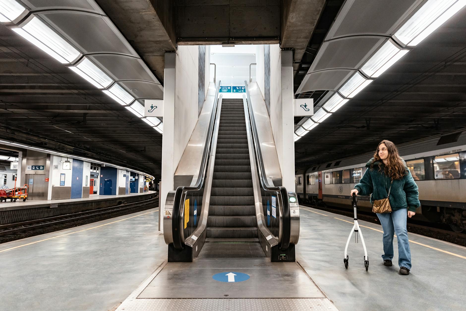 Traveler with a rollator on a modern train-station platform