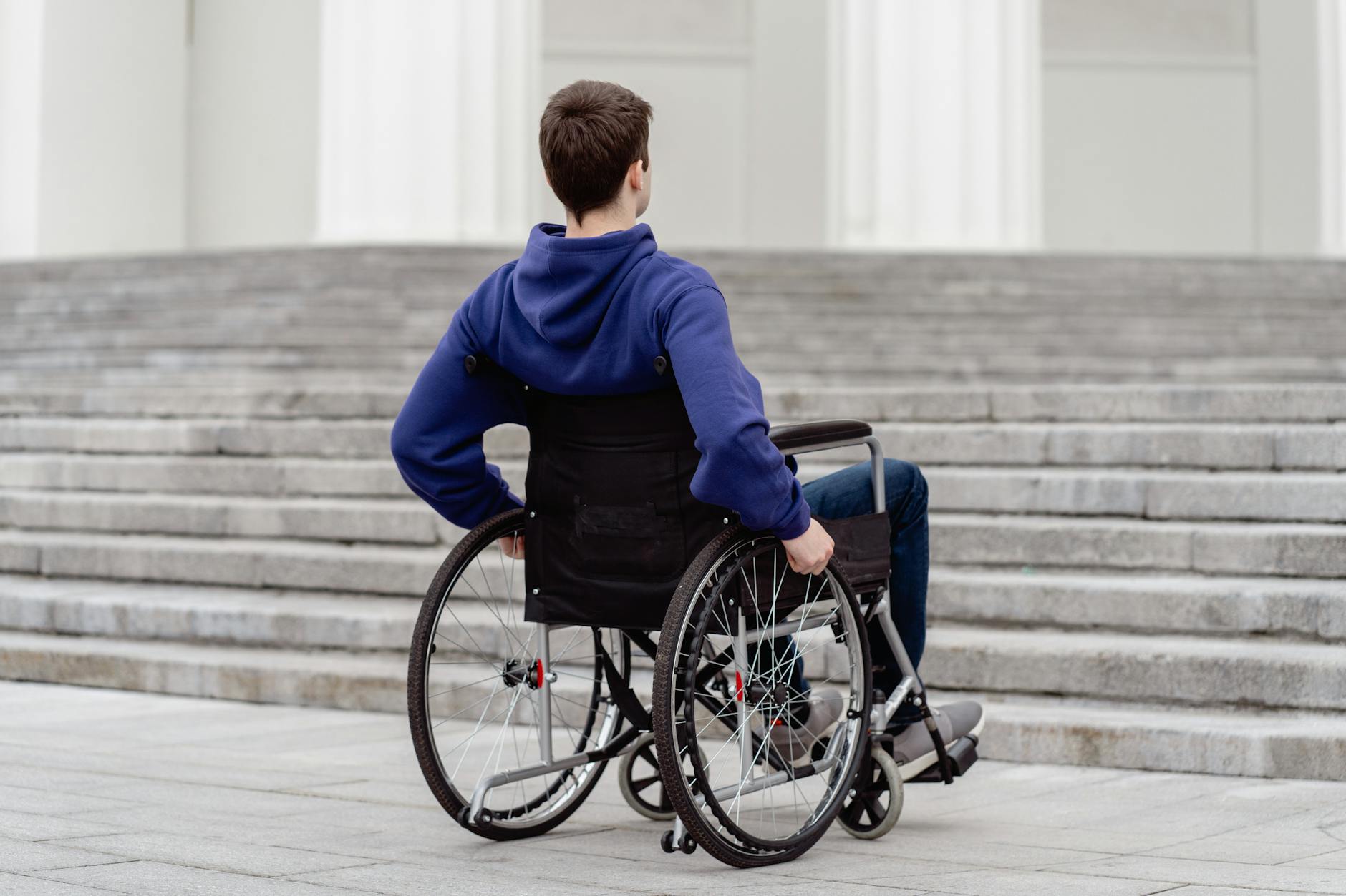 Wheelchair user facing steps in an urban setting