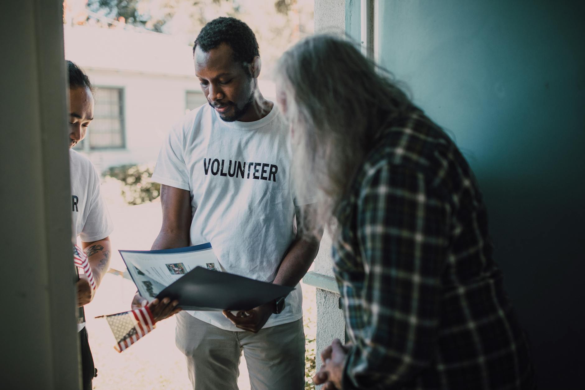 Volunteers visiting a home and reviewing documents