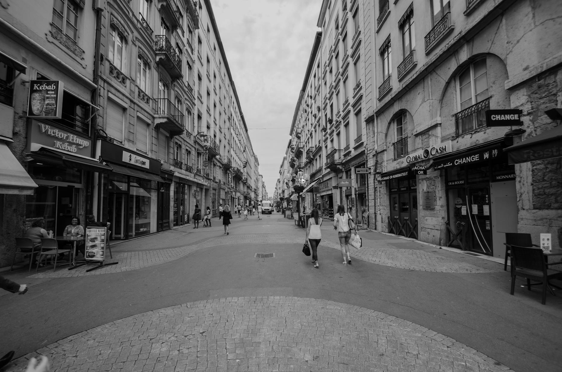 Pedestrians walking among shops and cafes on a city street