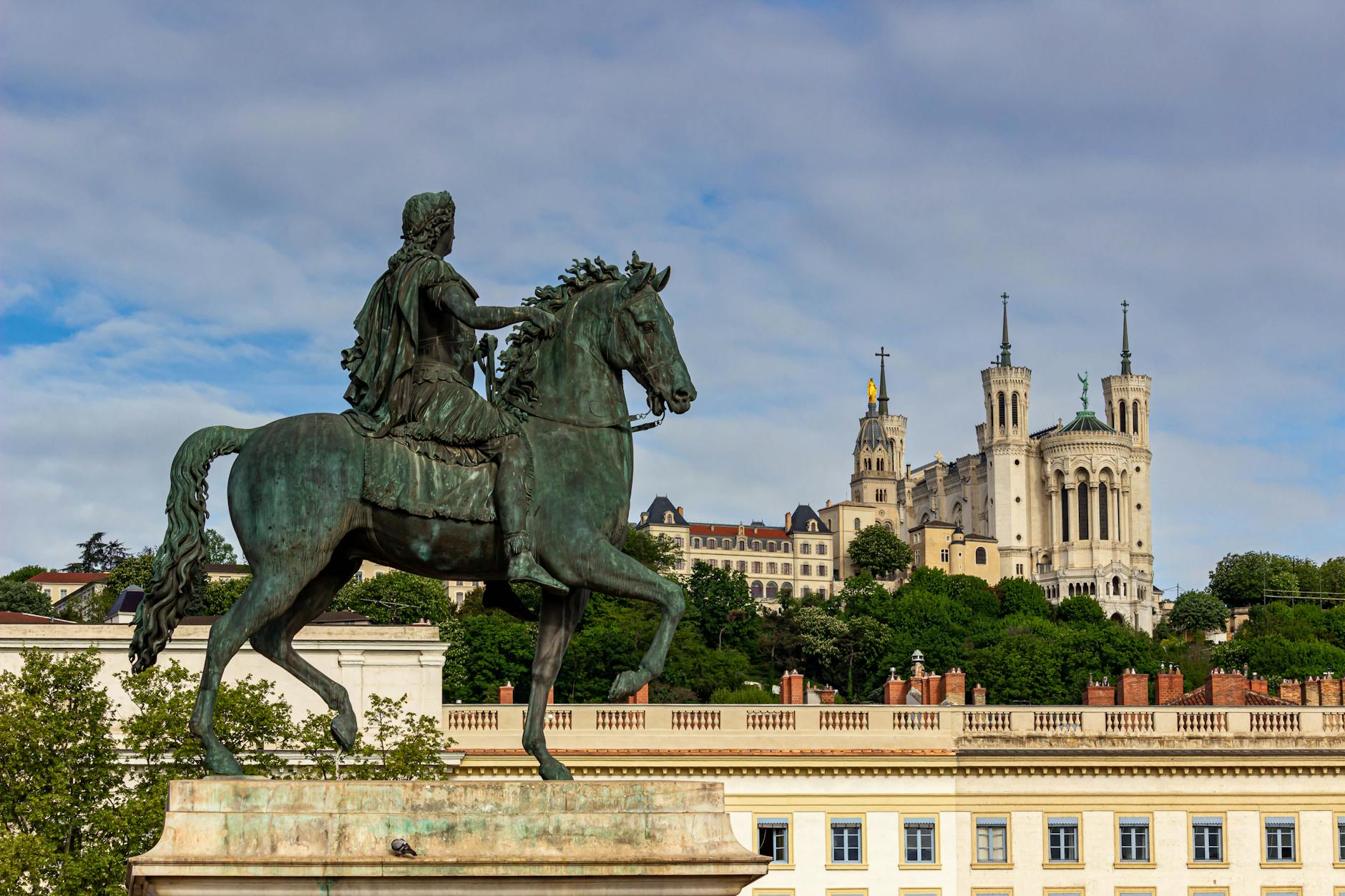 Place Bellecour statue with Fourviere in the background in Lyon