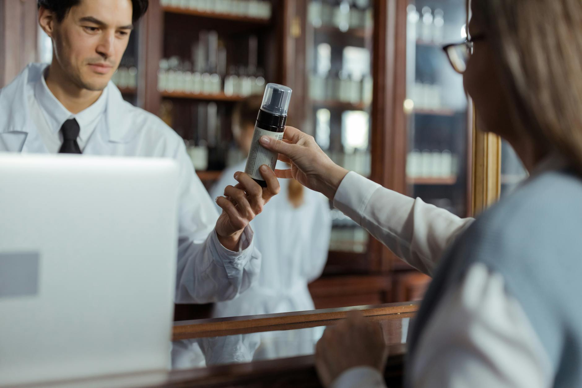 Pharmacist handing medication to a customer