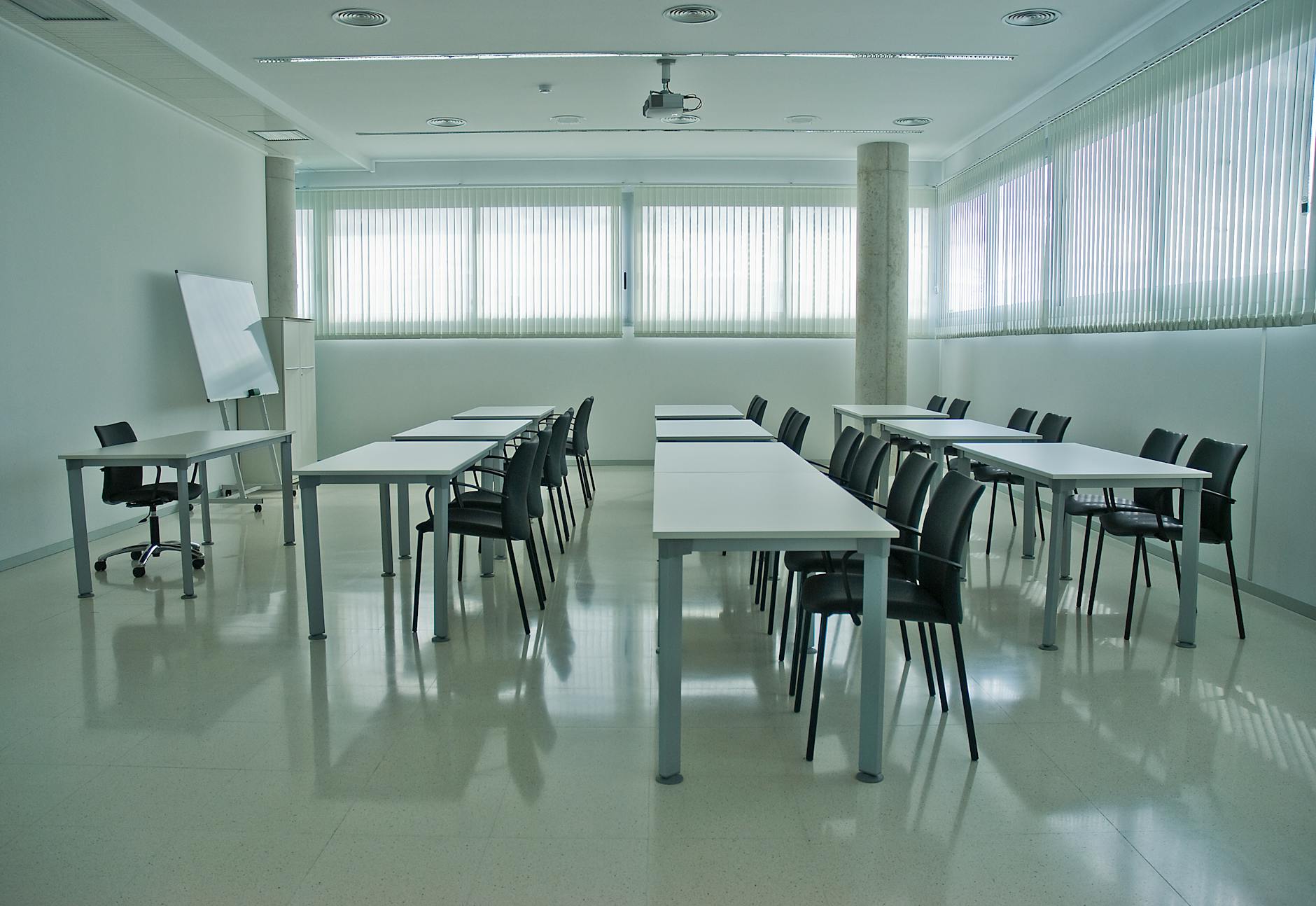 Modern conference room with desks, chairs, and whiteboard