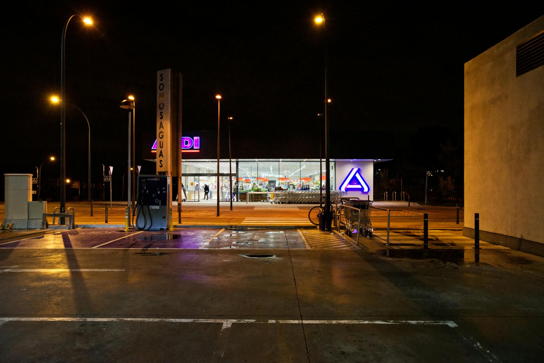 Illuminated supermarket and street at night in Madrid