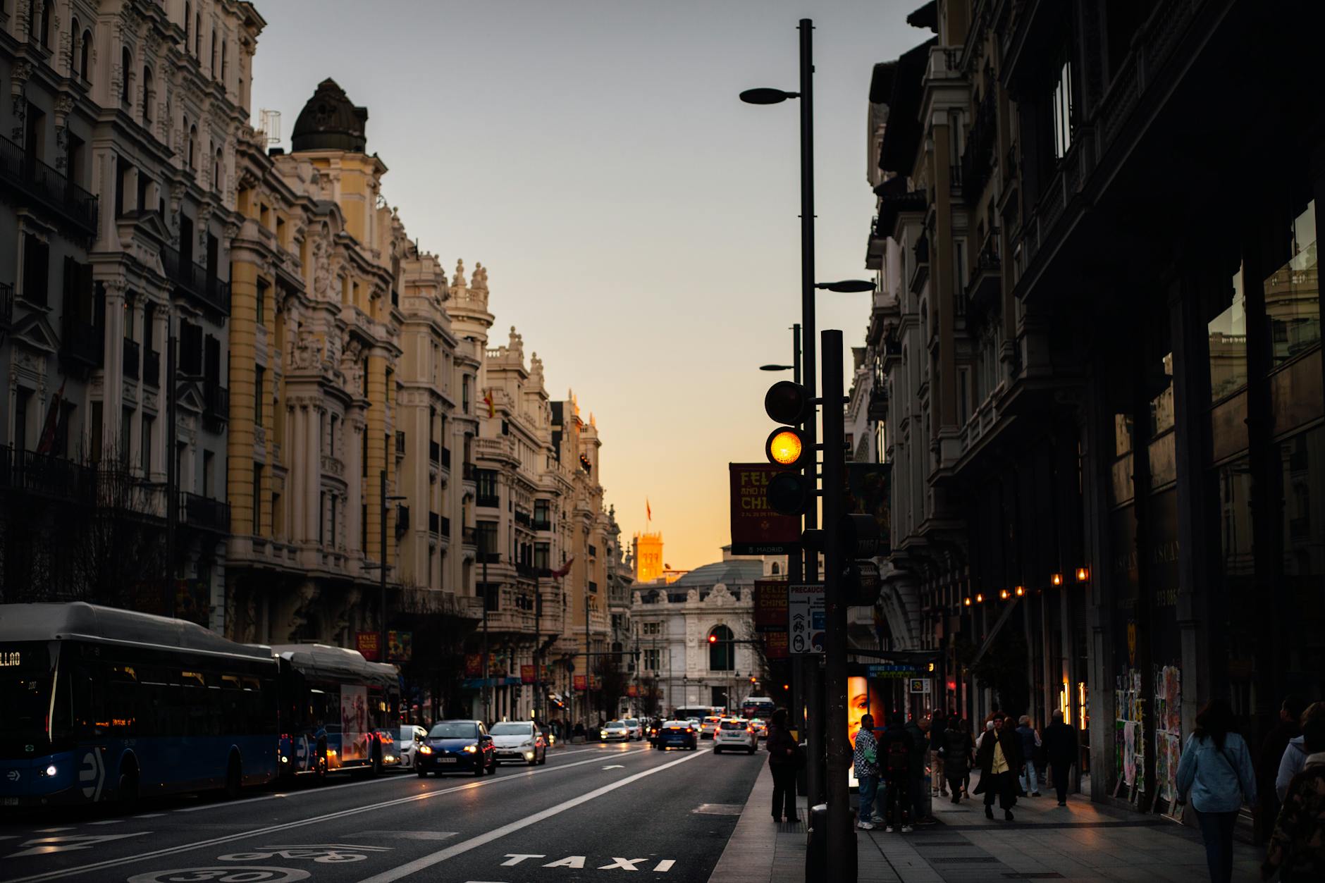 Madrid street at dusk with traffic and city landmarks