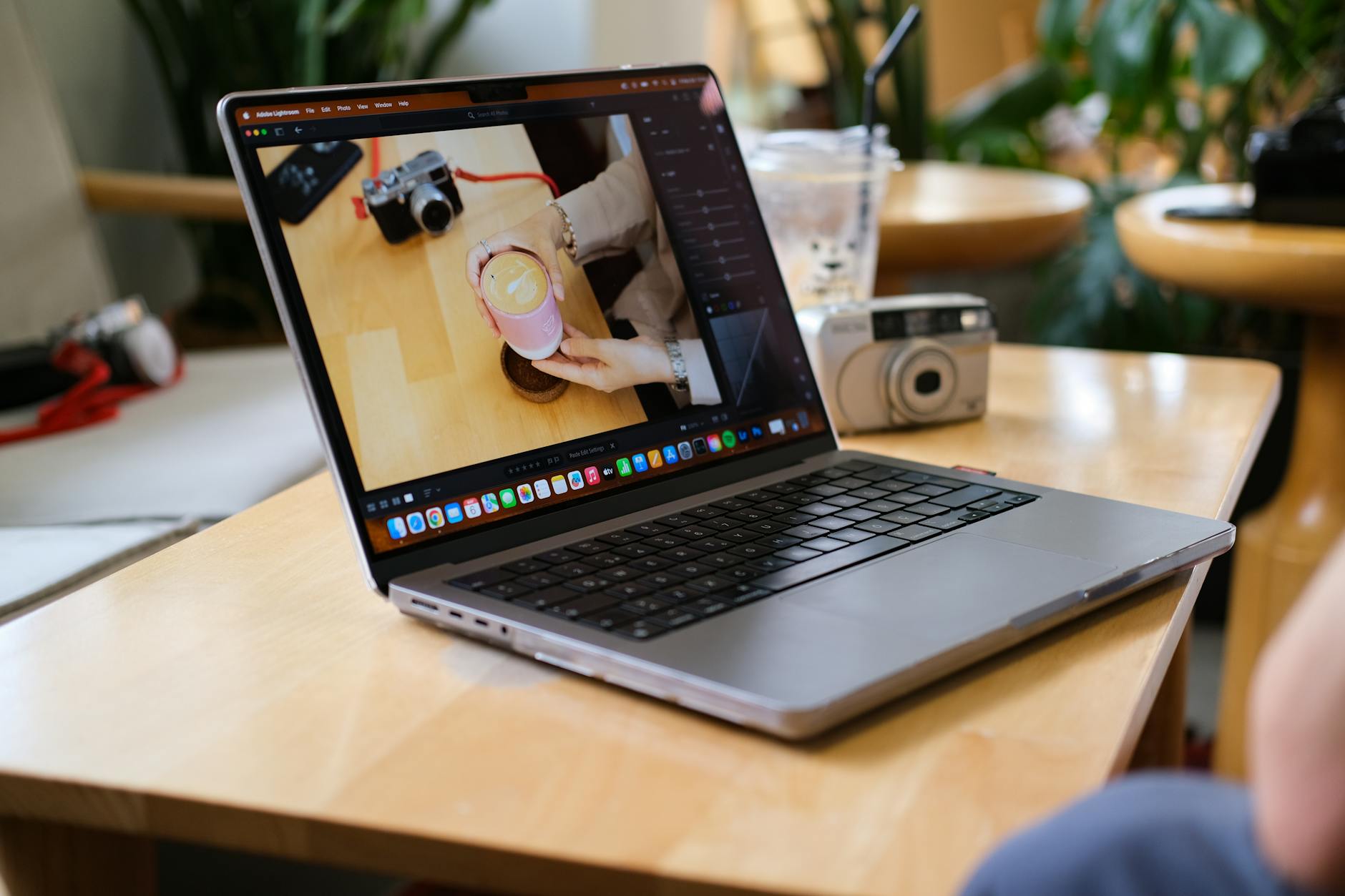 Laptop, coffee, and camera on a cafe table