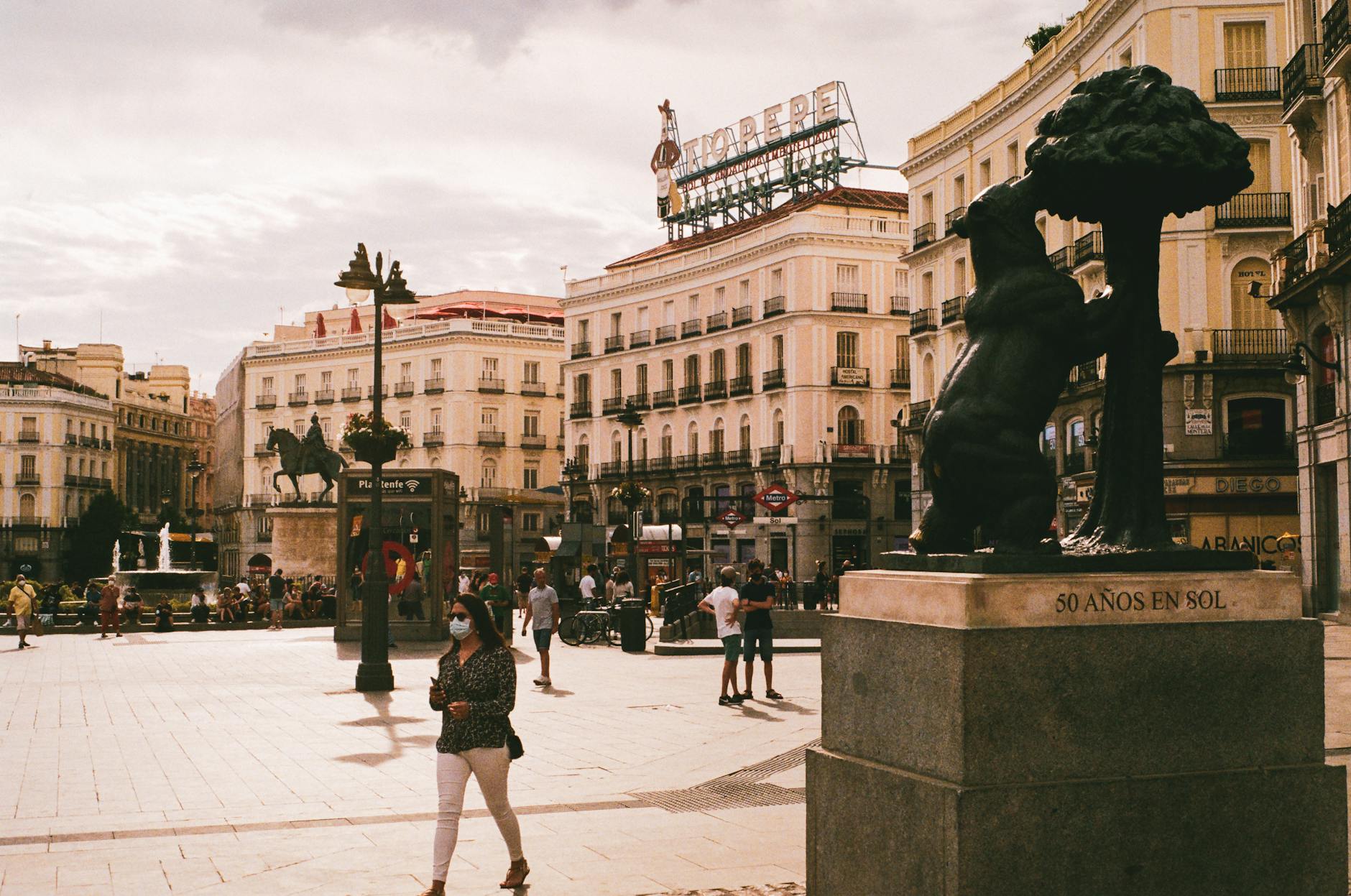 Puerta del Sol in Madrid with pedestrians and the Bear and Strawberry Tree sculpture