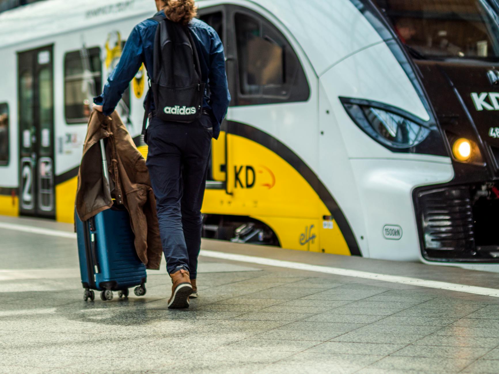 Traveler with suitcase preparing to board a train
