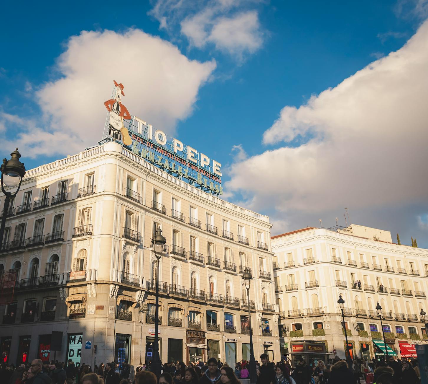 Crowded Puerta del Sol in Madrid with the Tio Pepe sign above the square