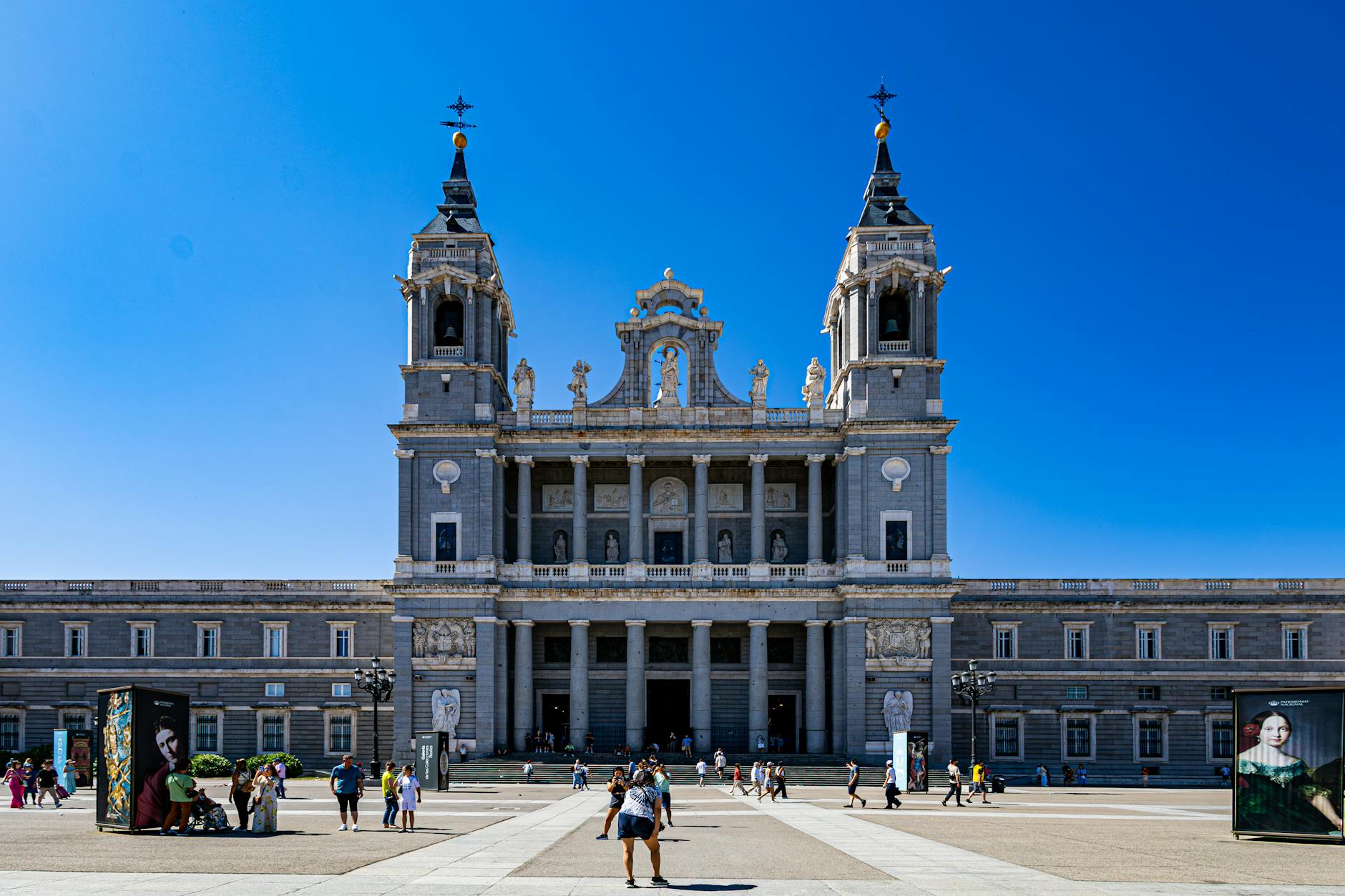 Almudena Cathedral in Madrid with visitors outside on a sunny day