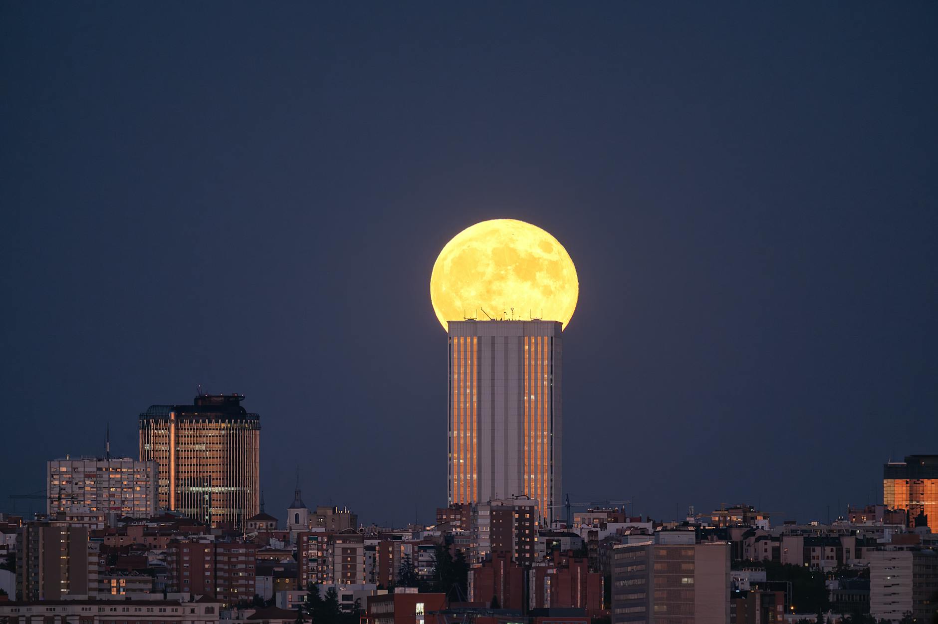 Full moon rising over Madrid's illuminated skyscrapers