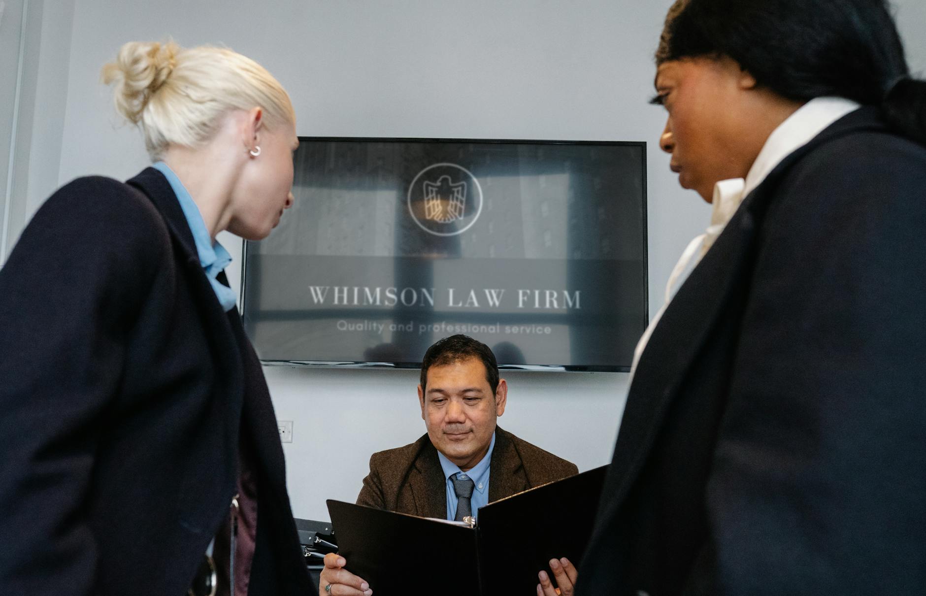 Professionals discussing contract details in a law-office meeting room
