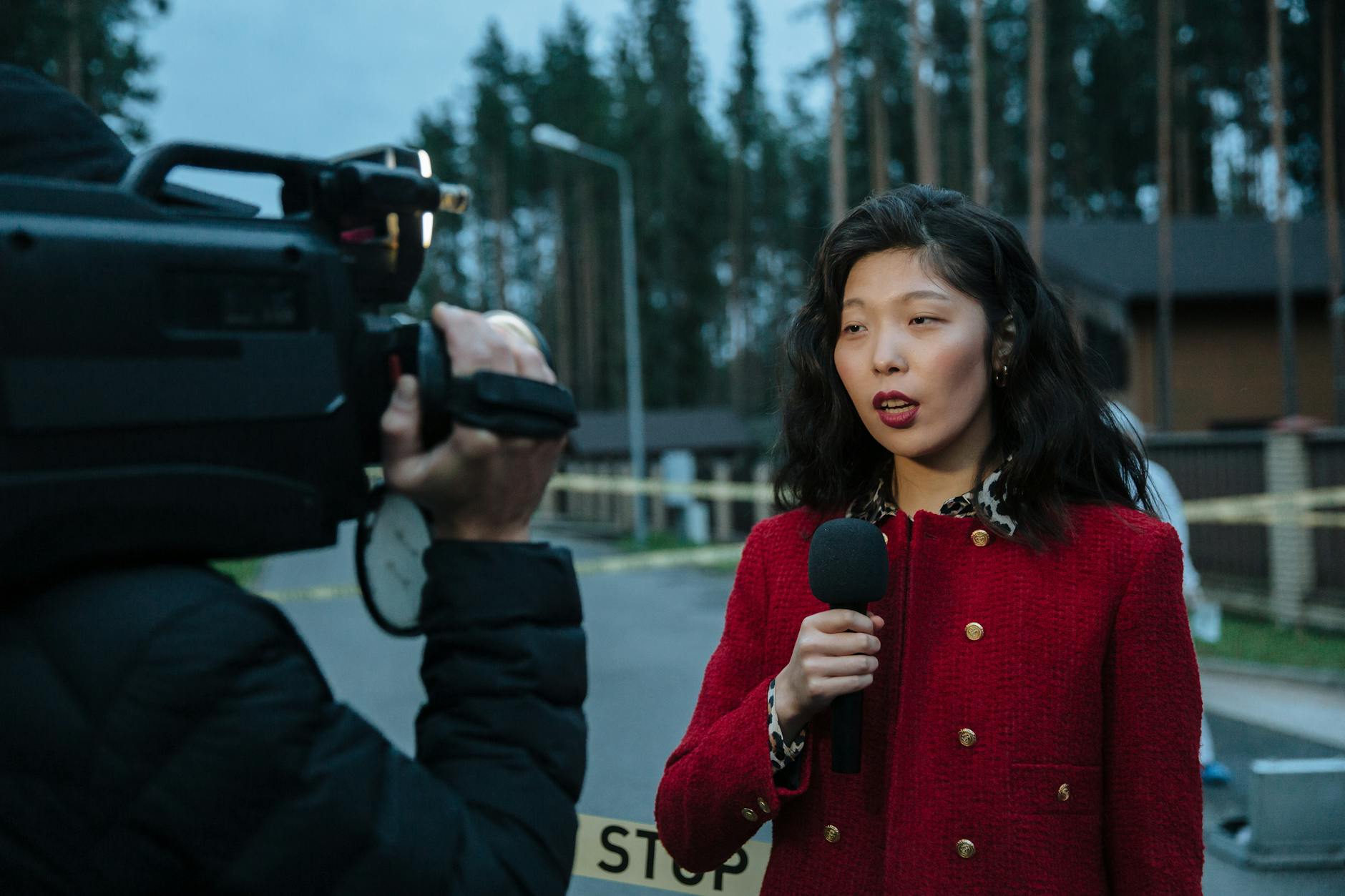 Reporter holding a microphone beside a camera crew